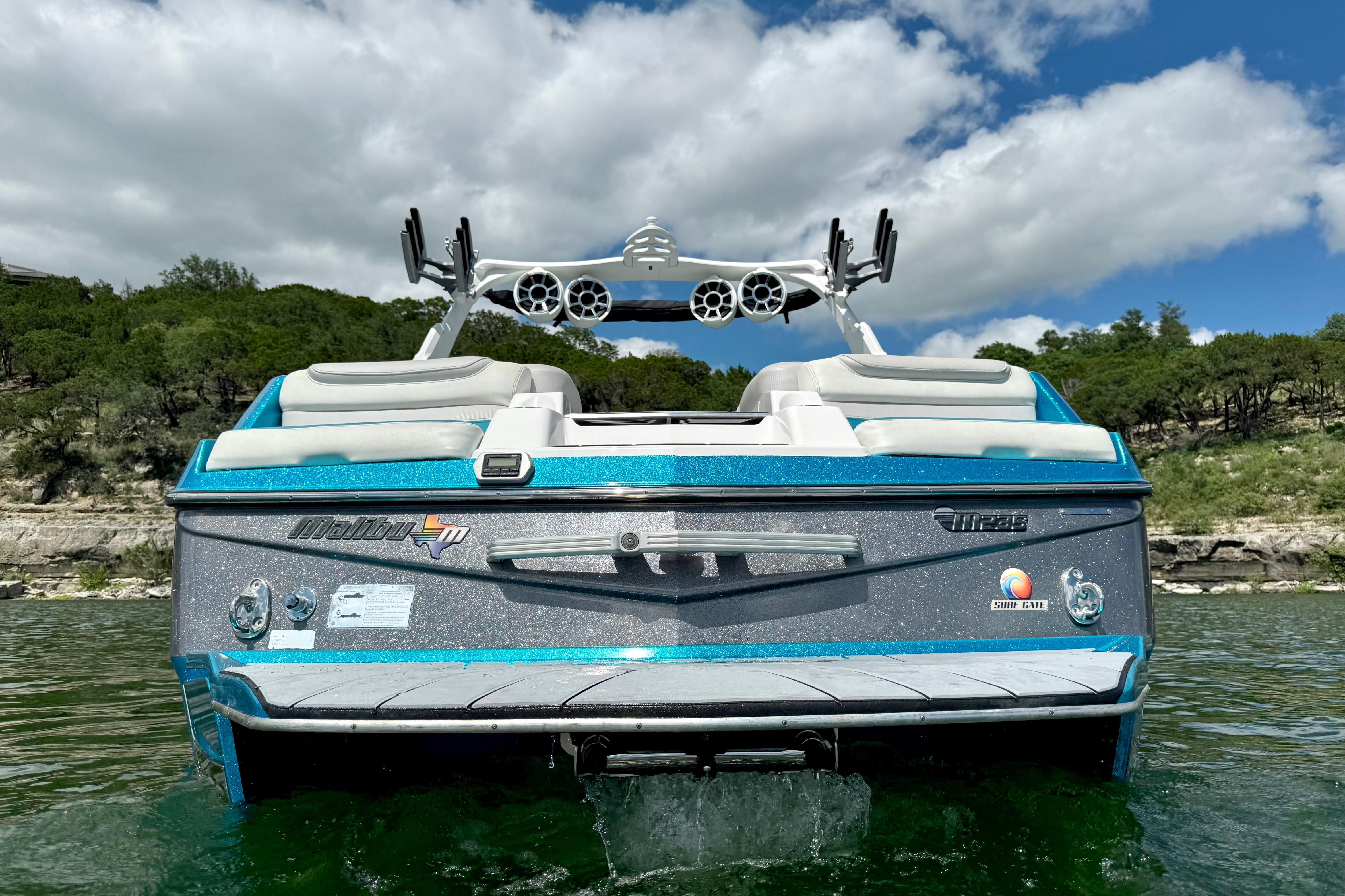 2017 Malibu M235 boat on water, showcasing sleek design and vibrant blue accents.