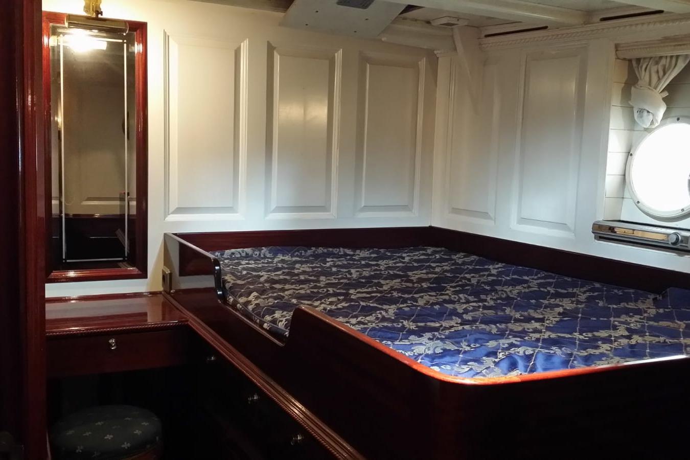 Luxurious cabin interior of 1930 Frederikksund Gaff Topsail Schooner with elegant wood finish.