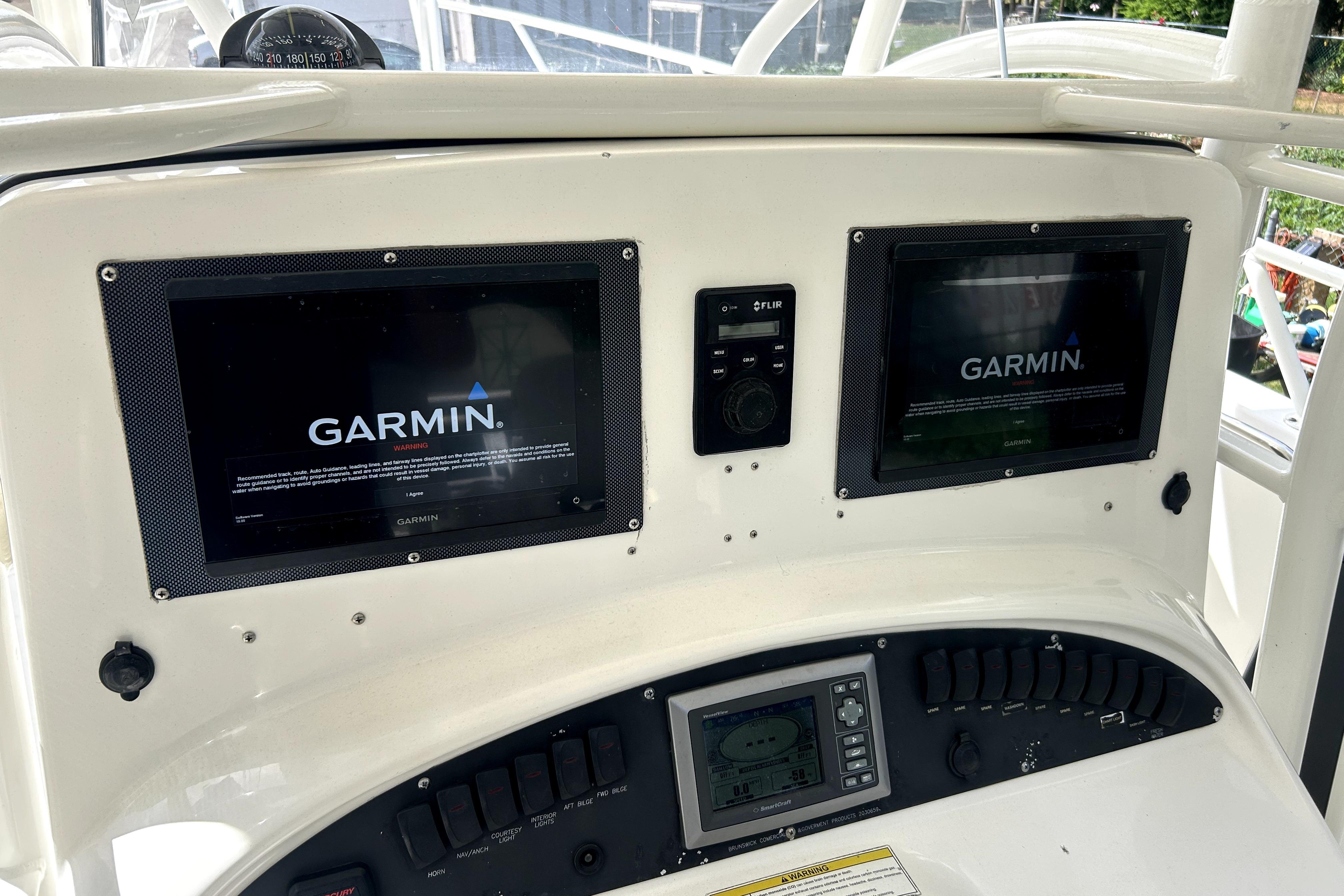 Control panel of a 2012 Boston Whaler 320 Outrage with Garmin navigation displays.