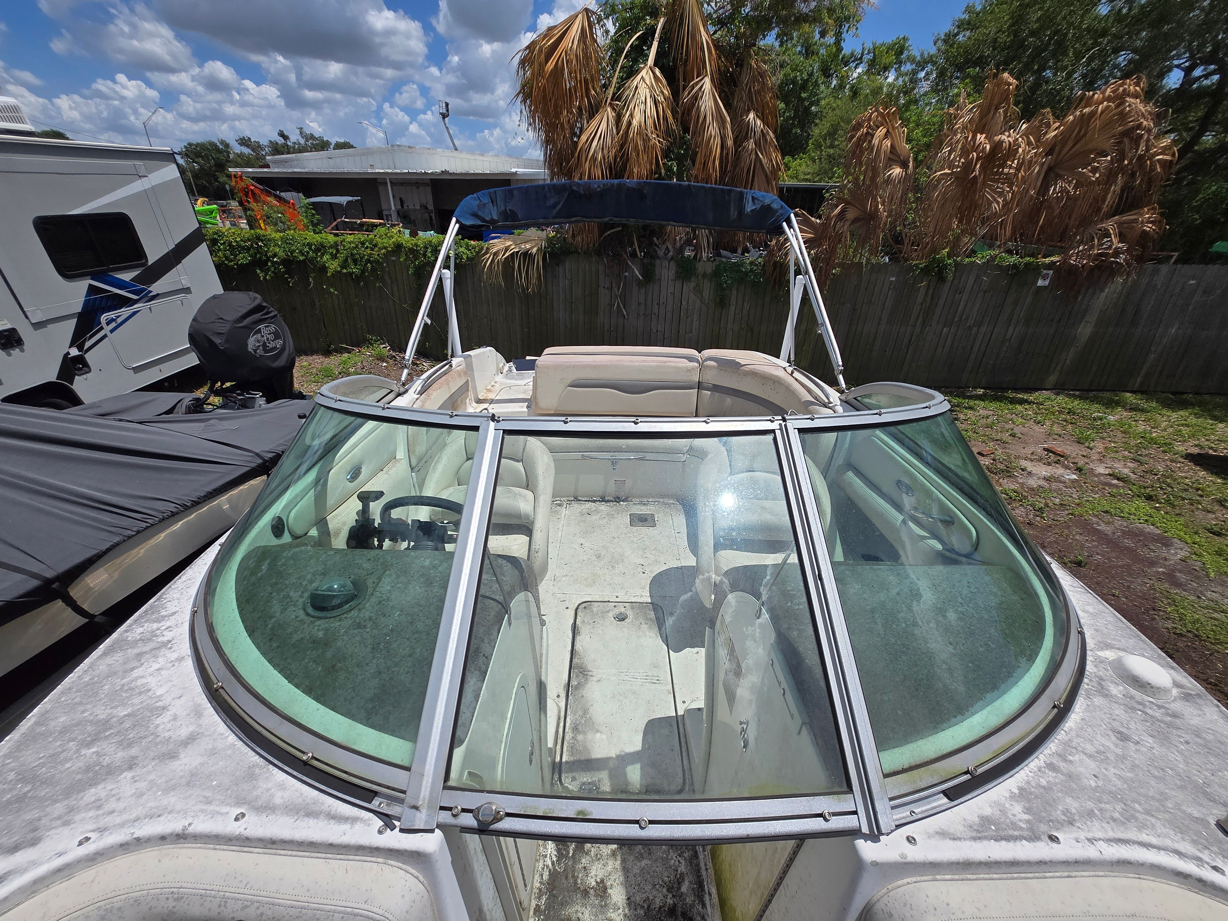 A 2006 Chaparral 220 SSi boat is on dry land with palm trees in the background.