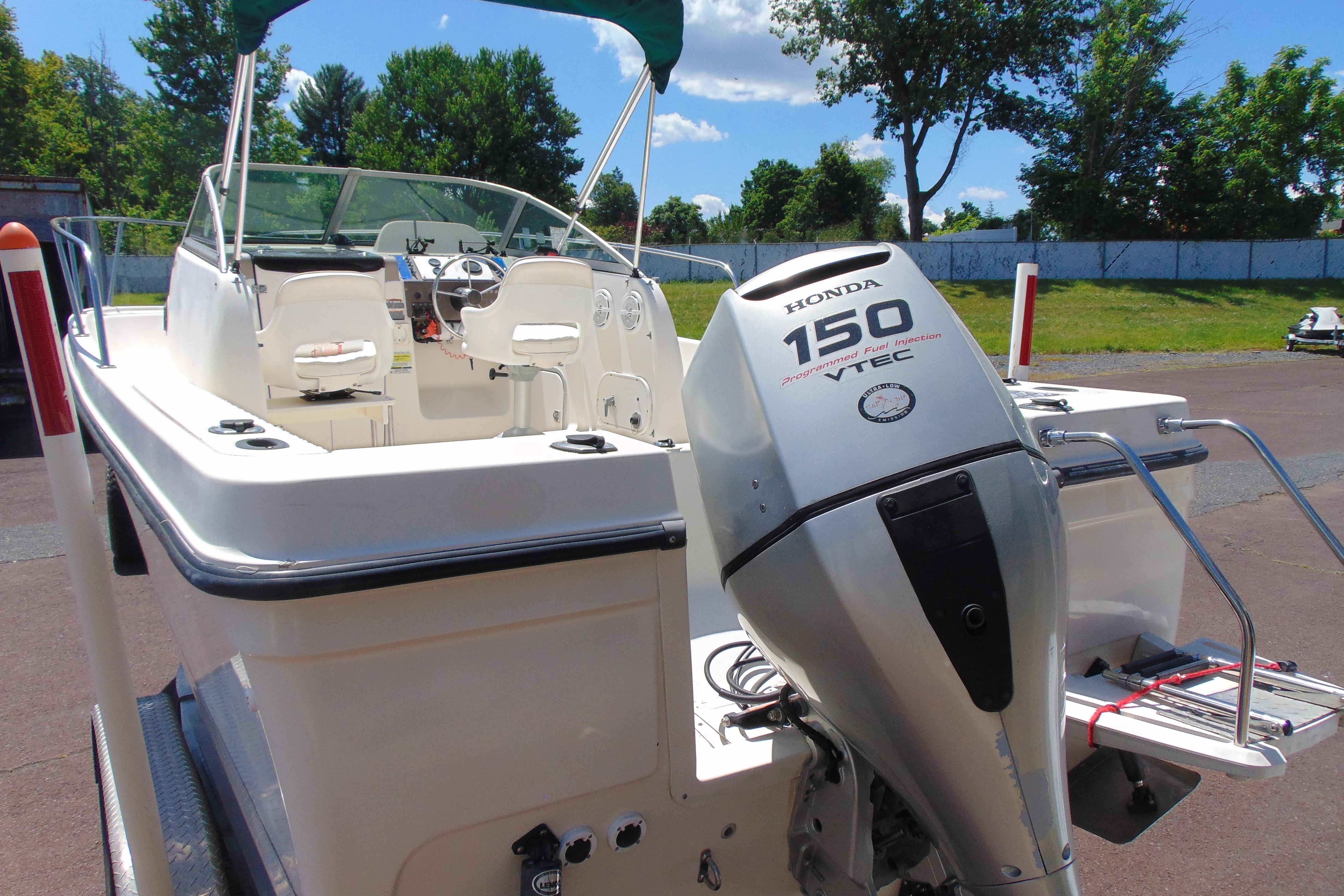 2002 Trophy Walkaround boat with Honda 150 VTEC engine, parked outdoors.