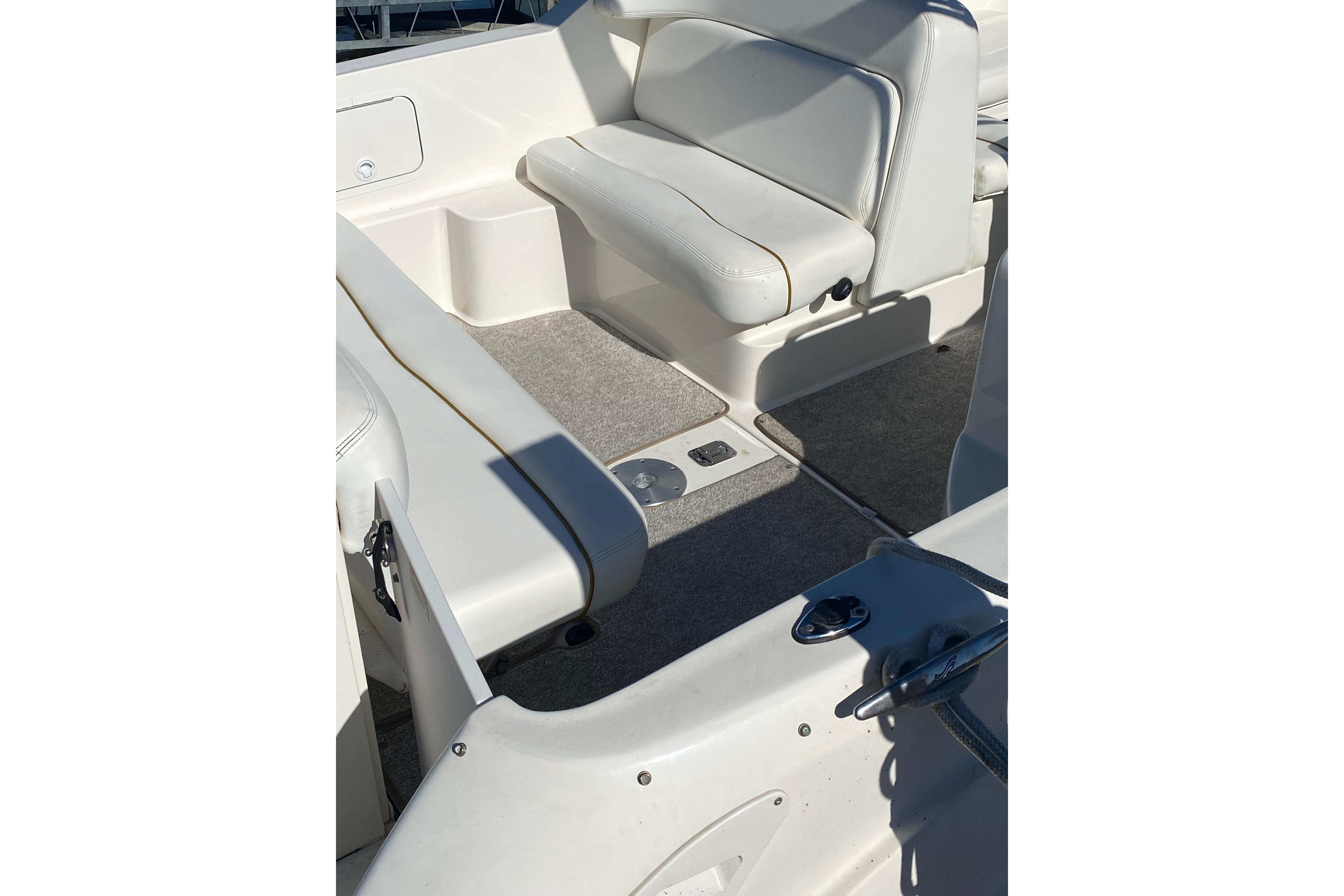 Interior view of a 2001 Sea Ray Sundancer 260 boat with white seating and carpeted floor.