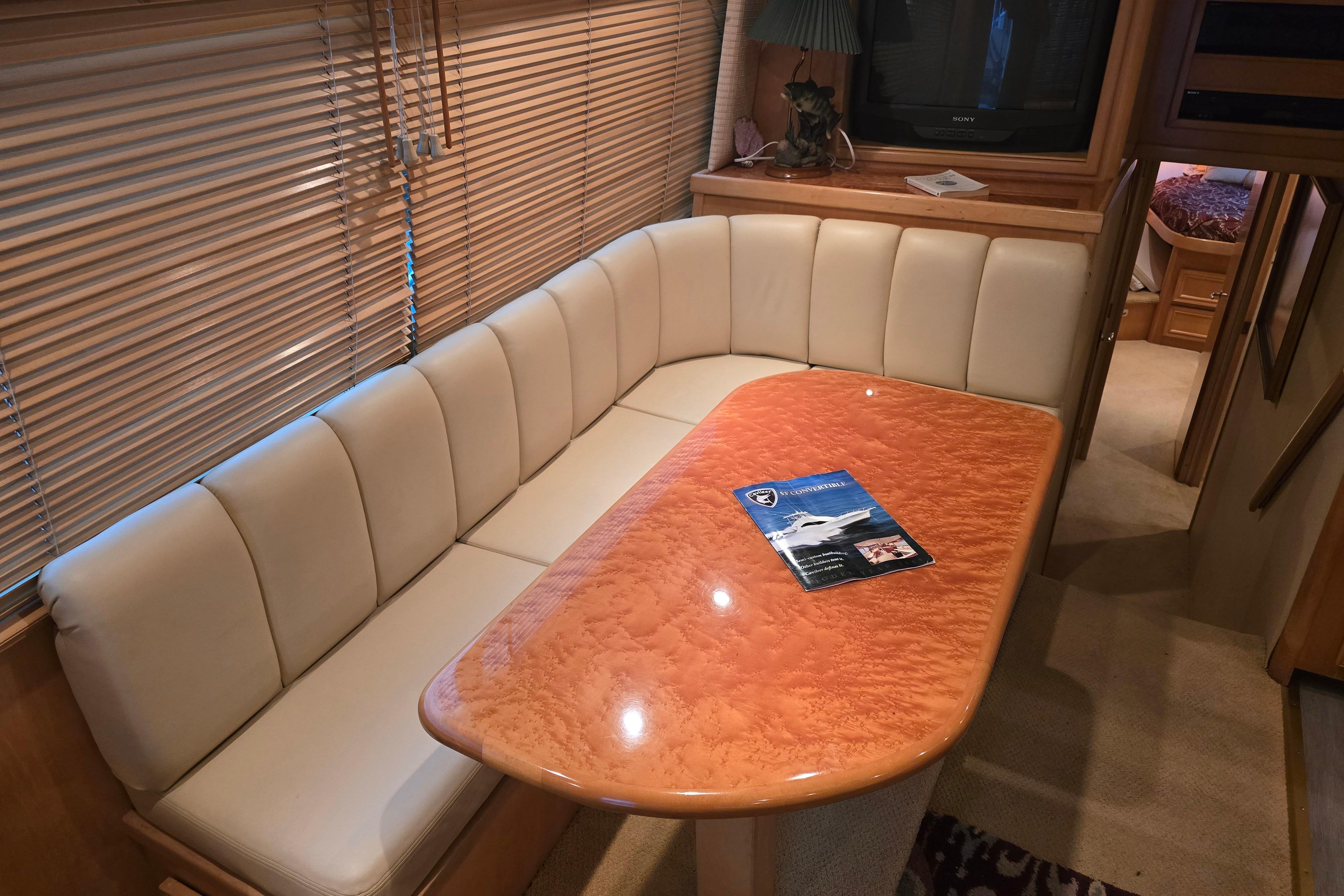 Luxurious interior of a 2001 Cavileer 53 Convertible yacht with elegant seating and wooden table.