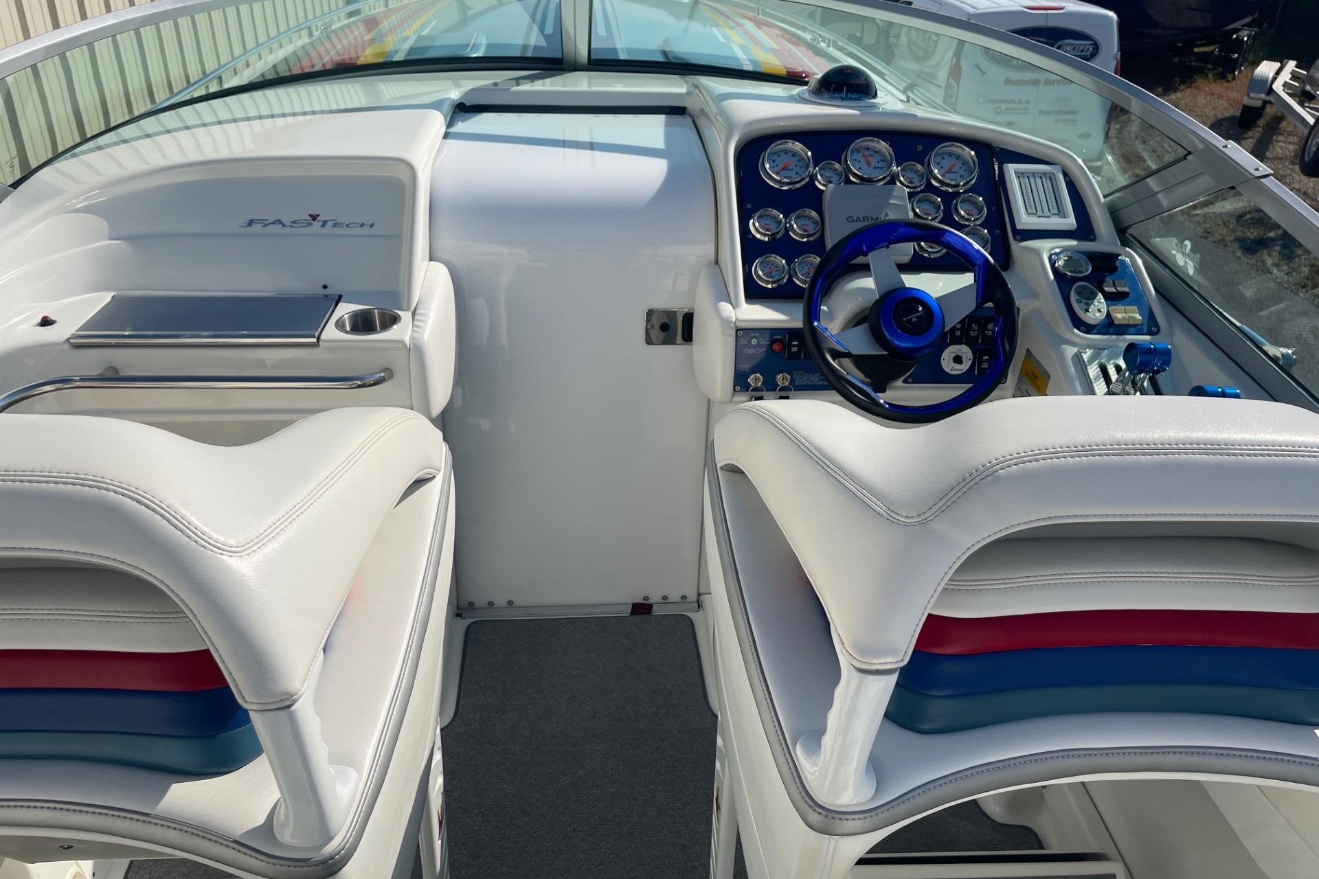 2004 Formula 382 FASTech boat interior with white seating and blue steering wheel.