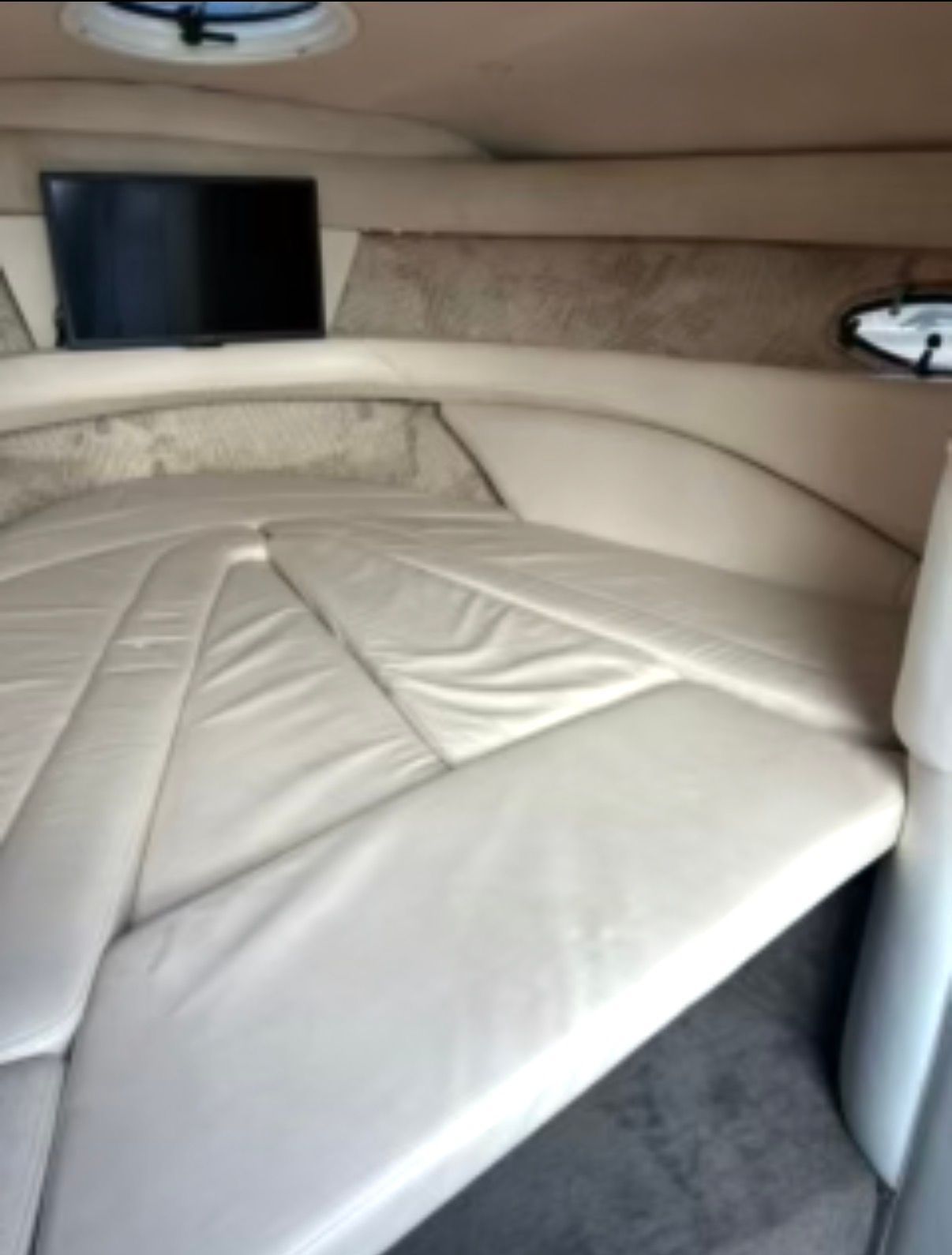 Interior of a 2001 Cobalt 293 with a cushioned lounging area and a small window.