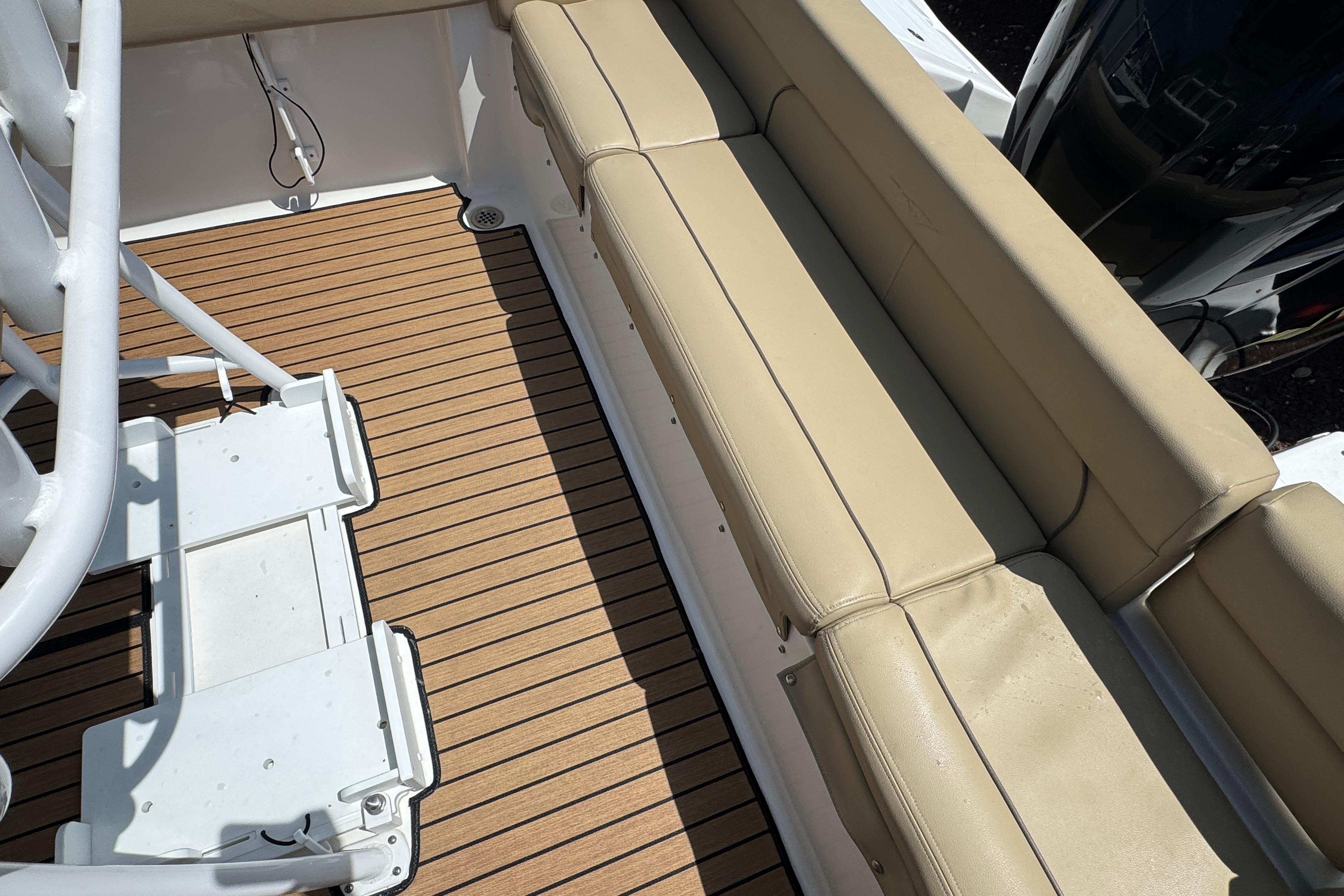 2016 Tidewater 230 LXF boat interior with beige seating and wood-patterned flooring.