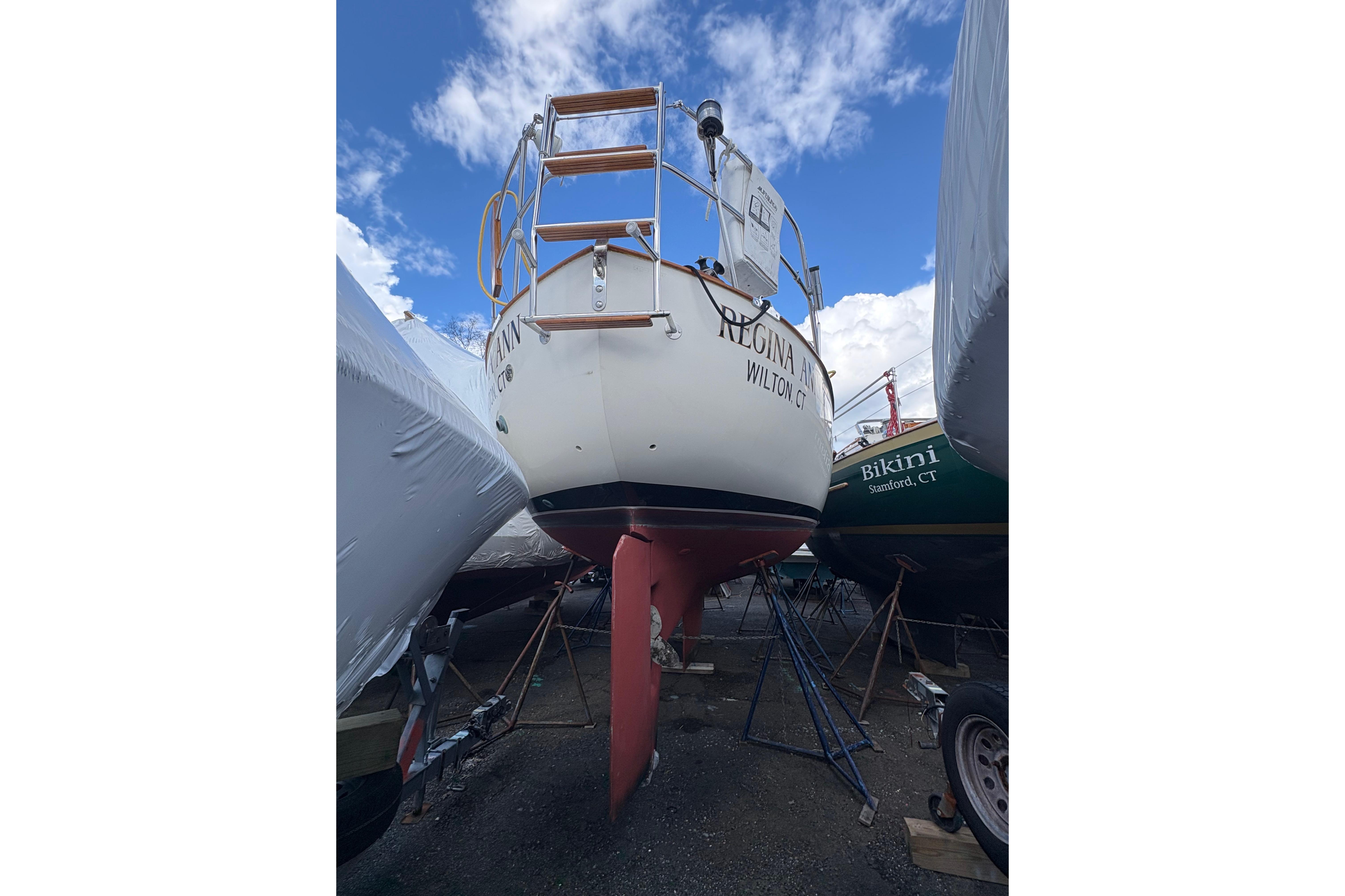 1997 Pacific Seacraft Crealock 34 sailboat on dry dock, rear view, under a blue sky.