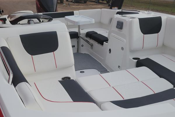 2024 Tahoe 1950 boat interior with white and black seating, red accents, and a small table.