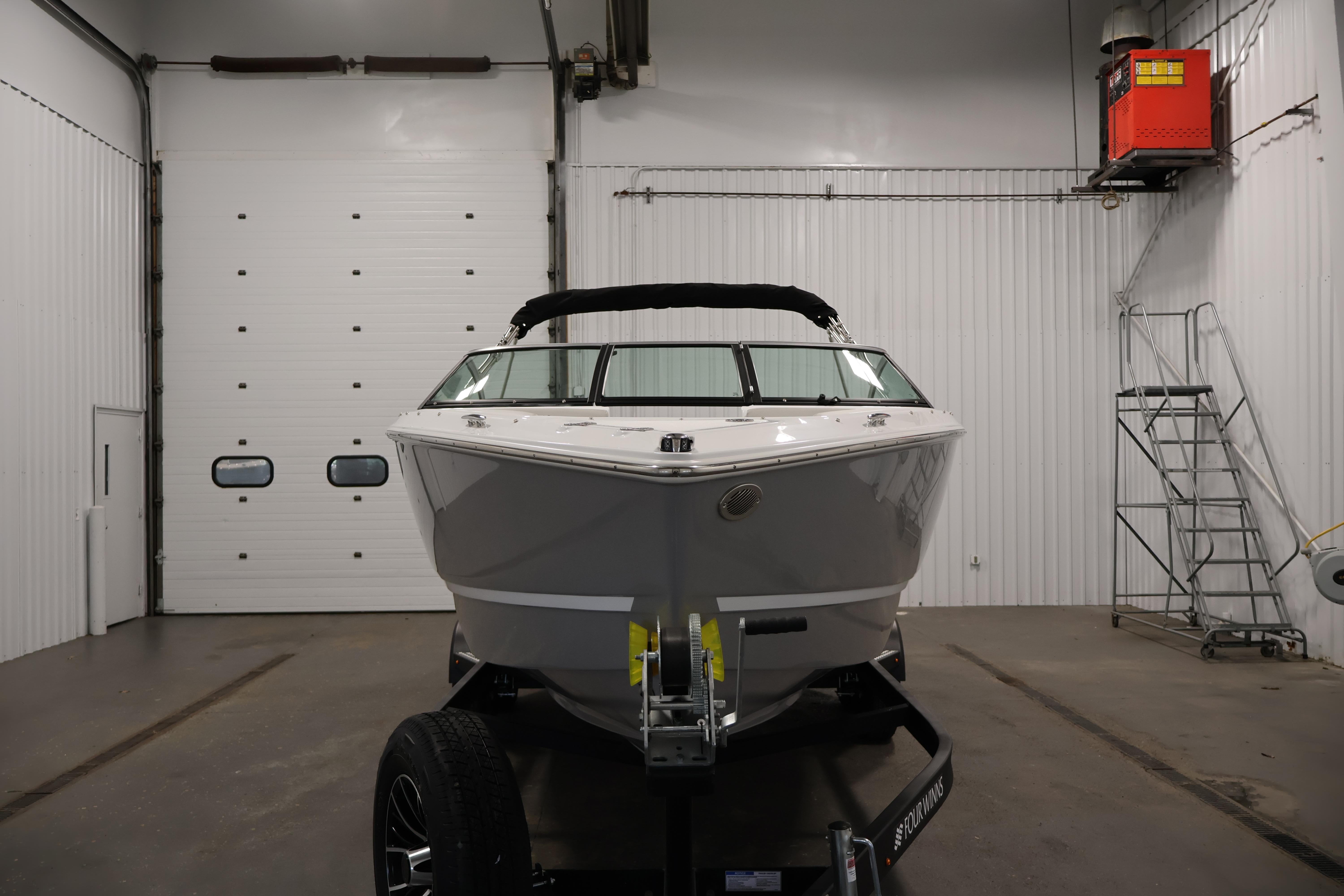 2026 Four Winns H4 Freedom boat in a garage, front view.