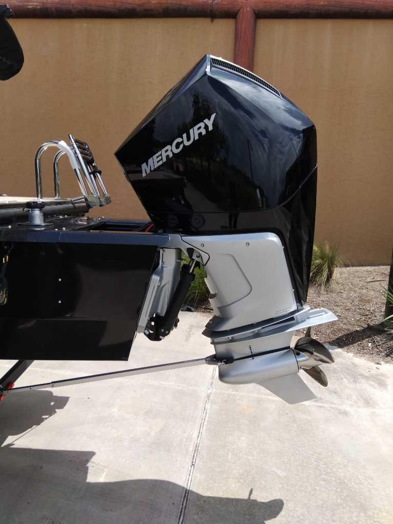 2025 Regency 250 LE3 boat with Mercury outboard motor, parked on concrete surface.