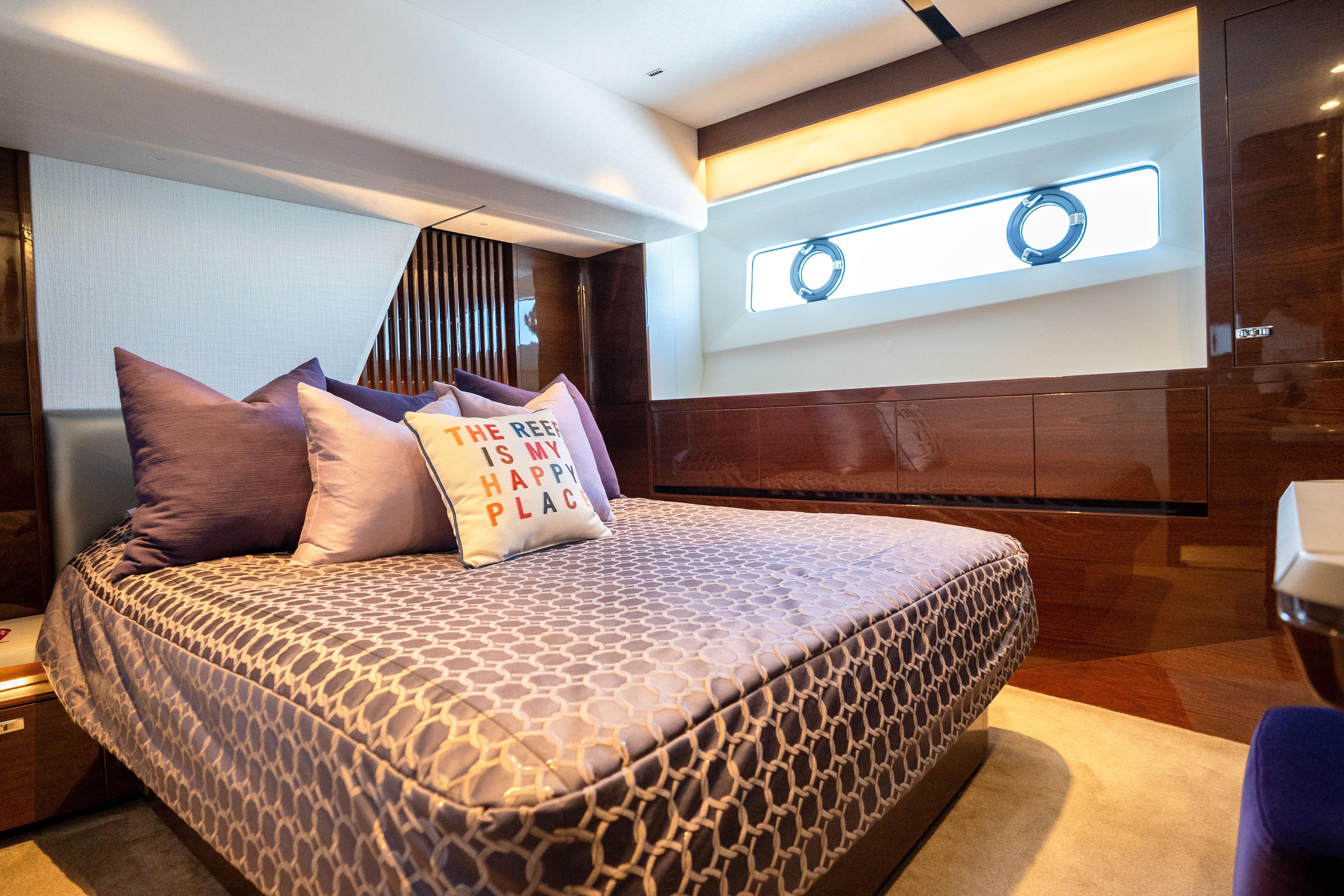 Luxurious bedroom interior of 2020 Princess Y85 yacht with elegant bedding and decorative pillows.