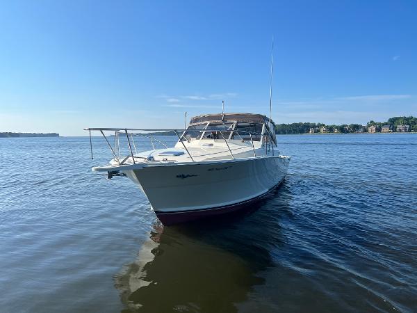 A 1985 Viking 35 Express boat on calm water with a clear sky.