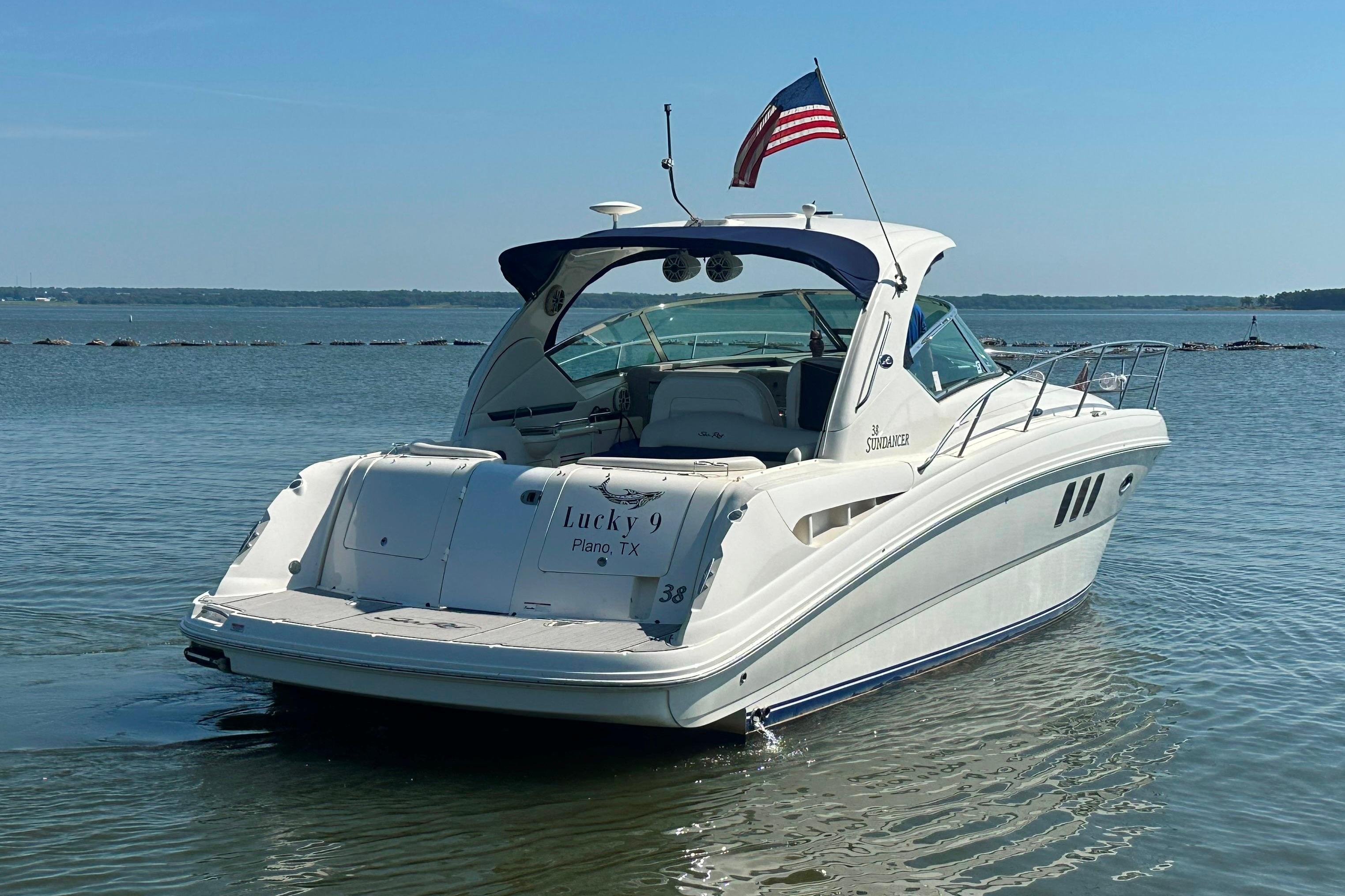 2007 Sea Ray 38 Sundancer boat on calm water with American flag.