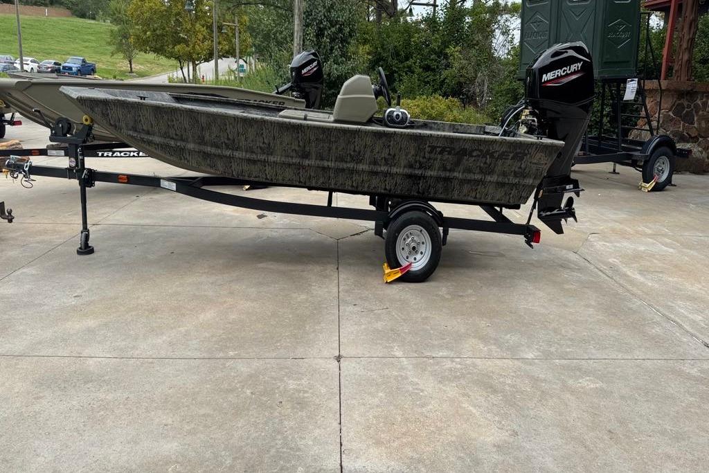 2026 Tracker Grizzly 1648 SC boat on trailer, parked outdoors.