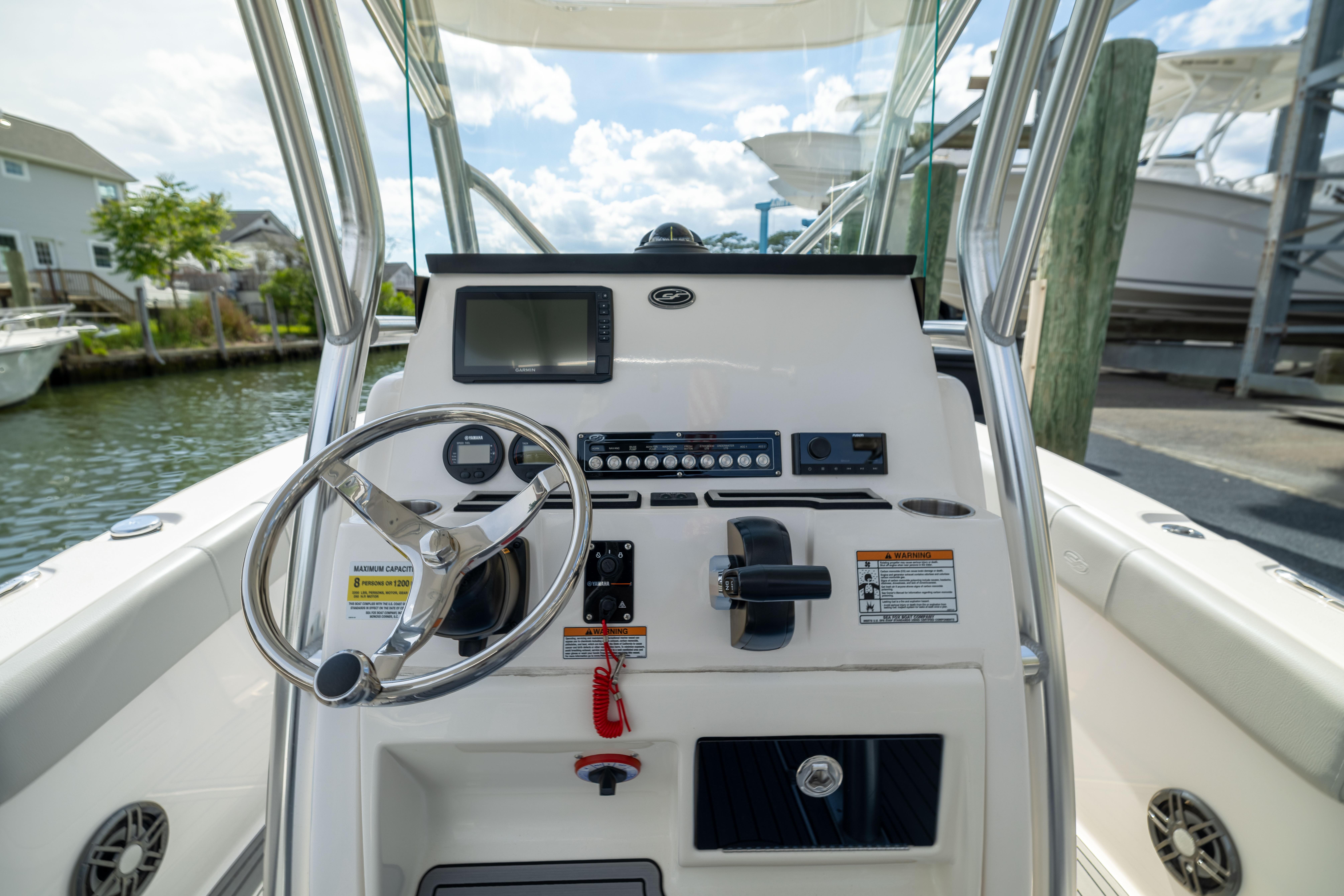 2023 Sea Fox 228 Commander boat console with steering wheel and navigation controls.