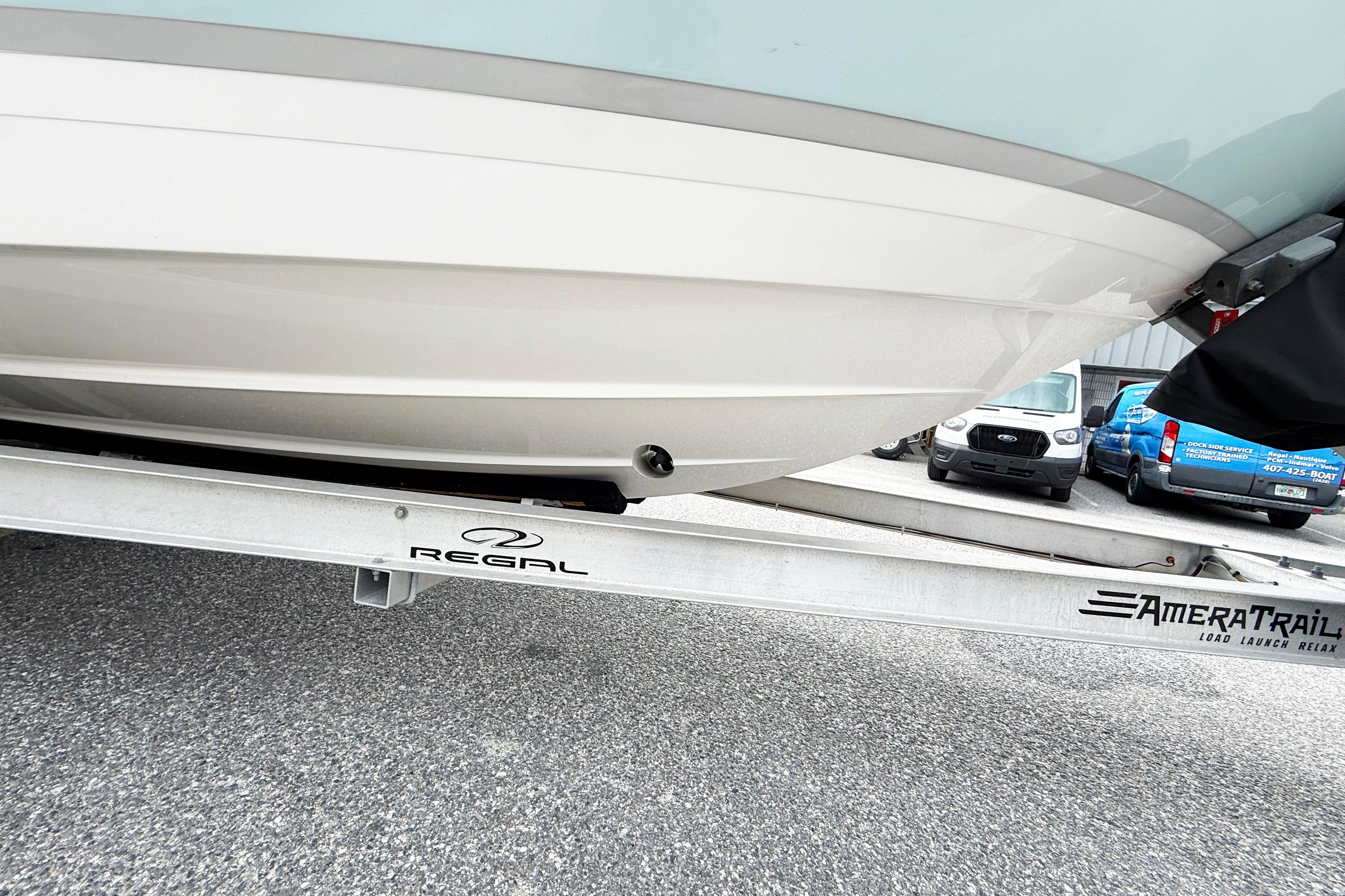 2024 Regal LX4 boat on AmeraTrail trailer, parked on asphalt.