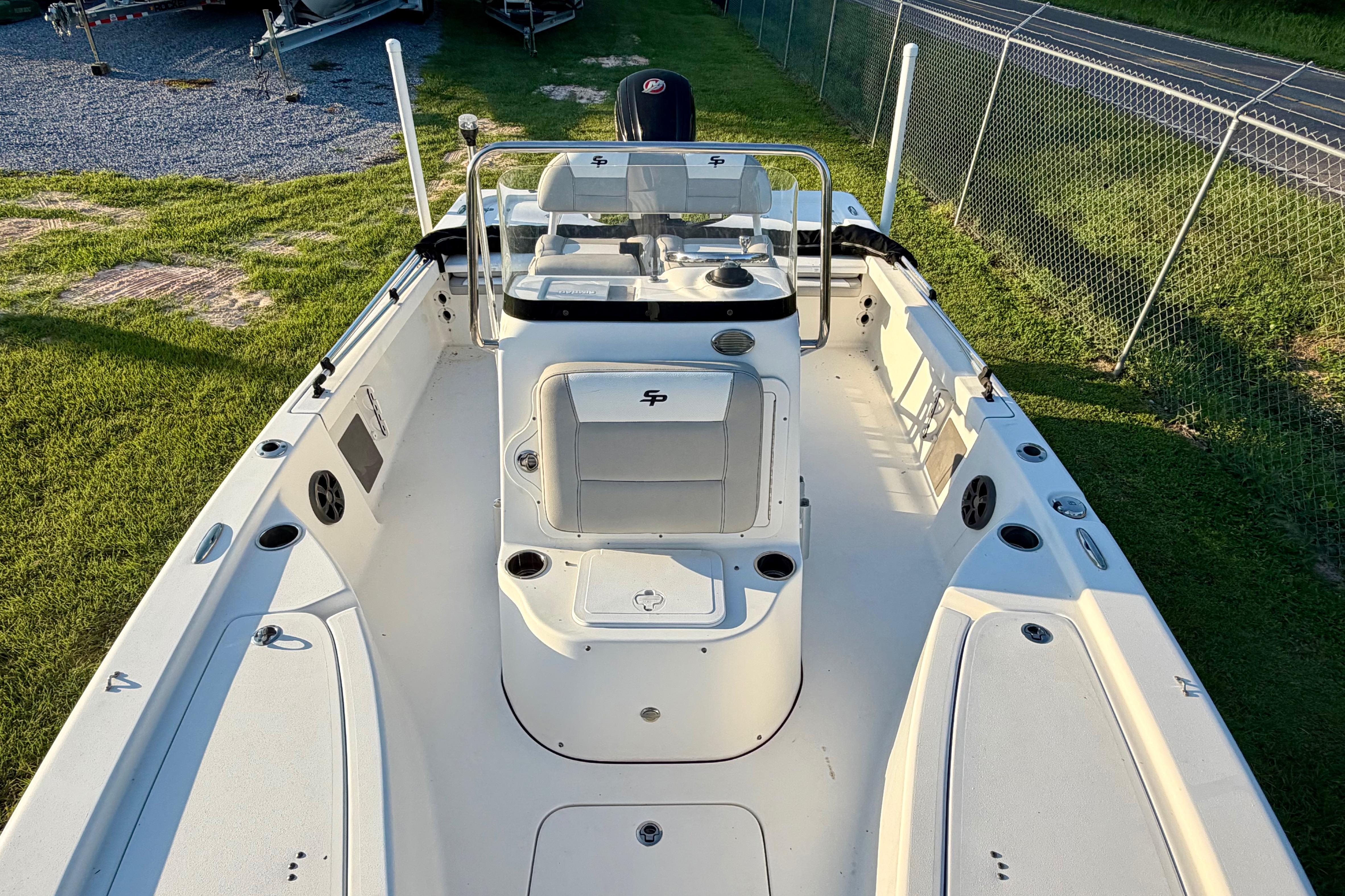 2018 Sea Pro 208 Bay boat, white interior, spacious deck, and seating, parked on grass.