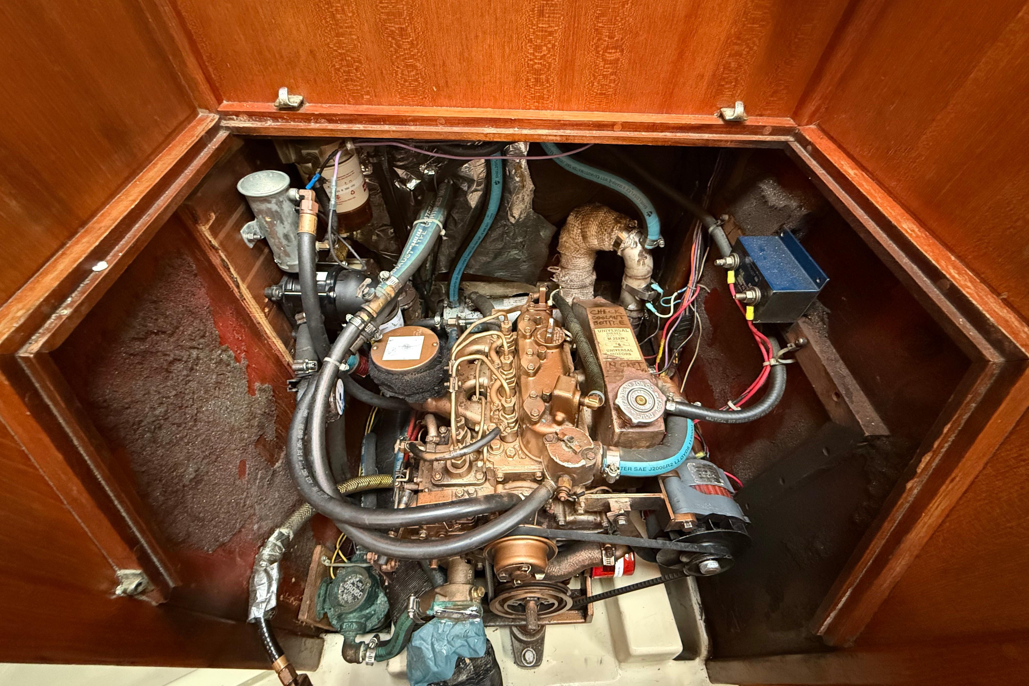 Engine compartment of a 1988 Ericson 32-200 sailboat, showcasing mechanical components and wiring.