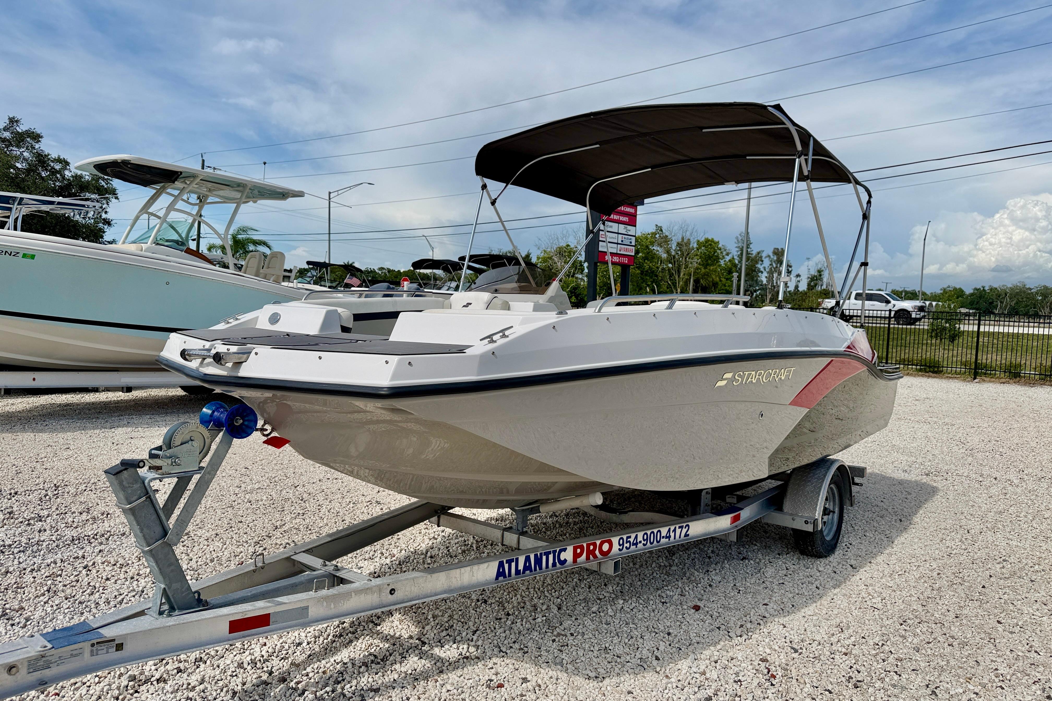 2021 Starcraft SVX 191 OB boat on trailer, parked outdoors under a cloudy sky.