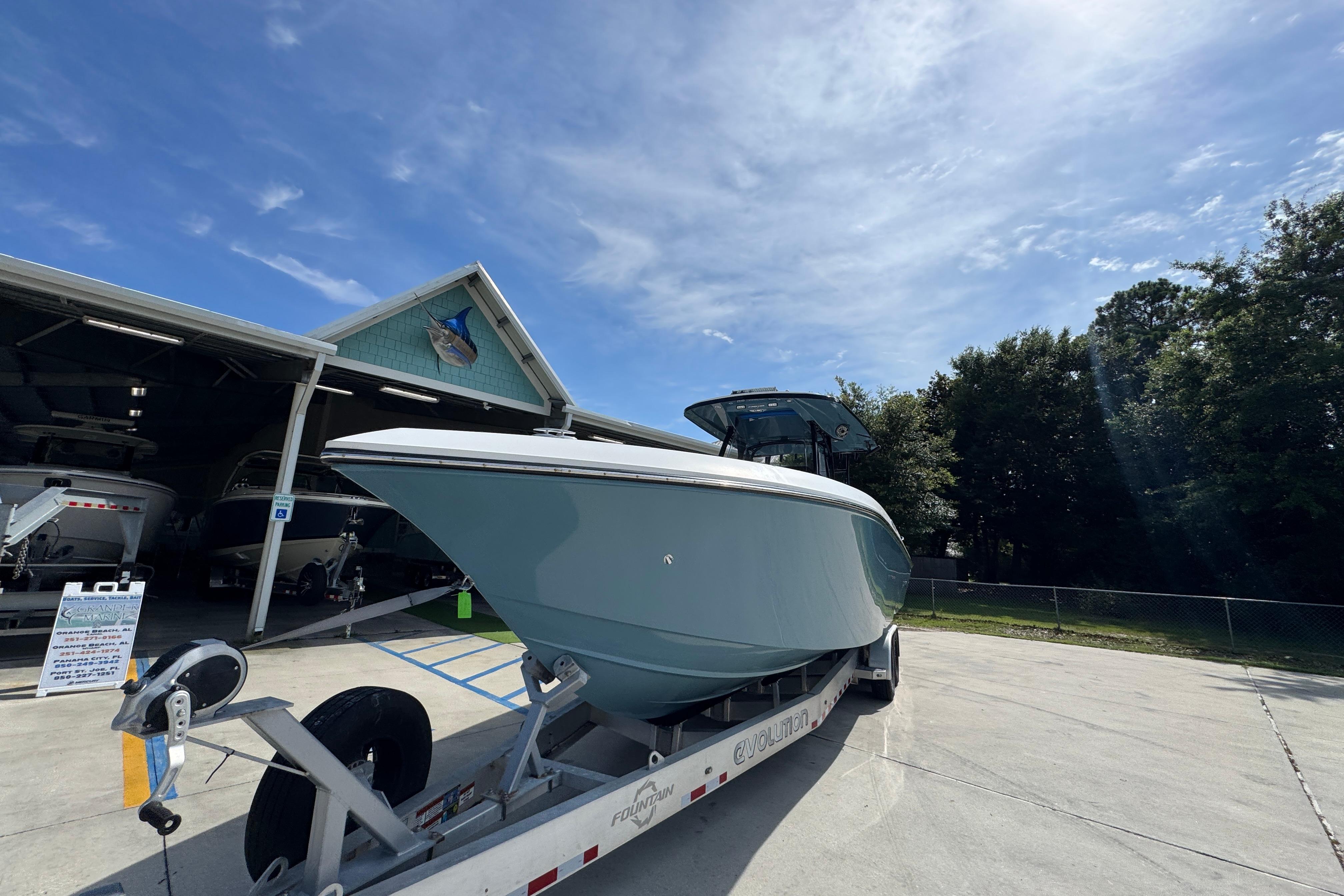 2023 Fountain 34 Tournament Edition boat on trailer under clear sky.