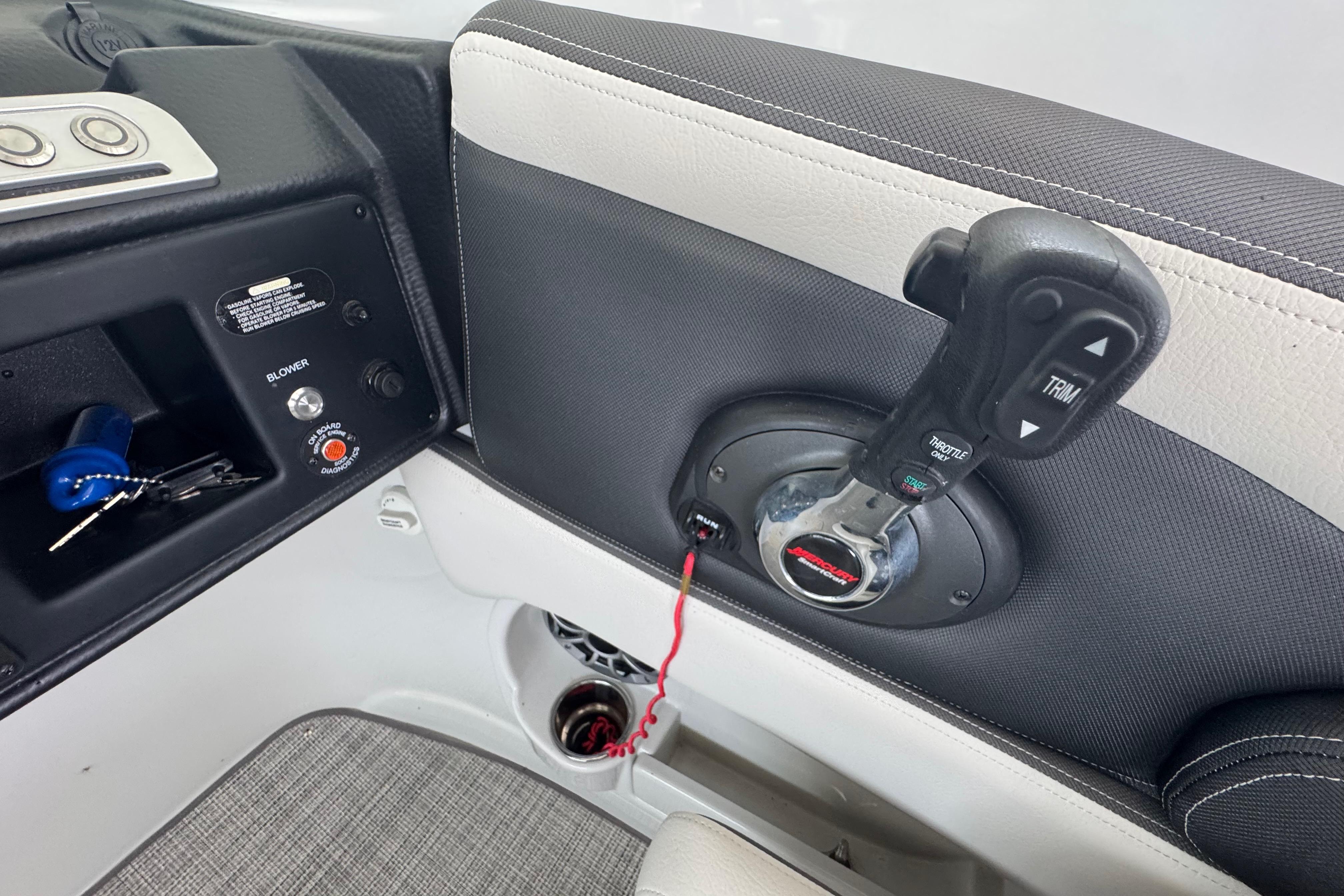 Interior controls of a 2022 Crownline 265 SS boat, featuring throttle and trim levers.