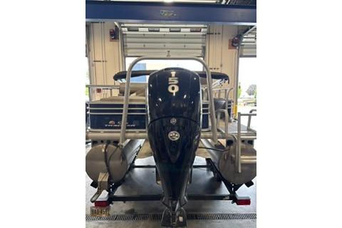 2022 Sun Tracker Fishin' Barge 22 DLX with 150 HP engine in a garage setting.