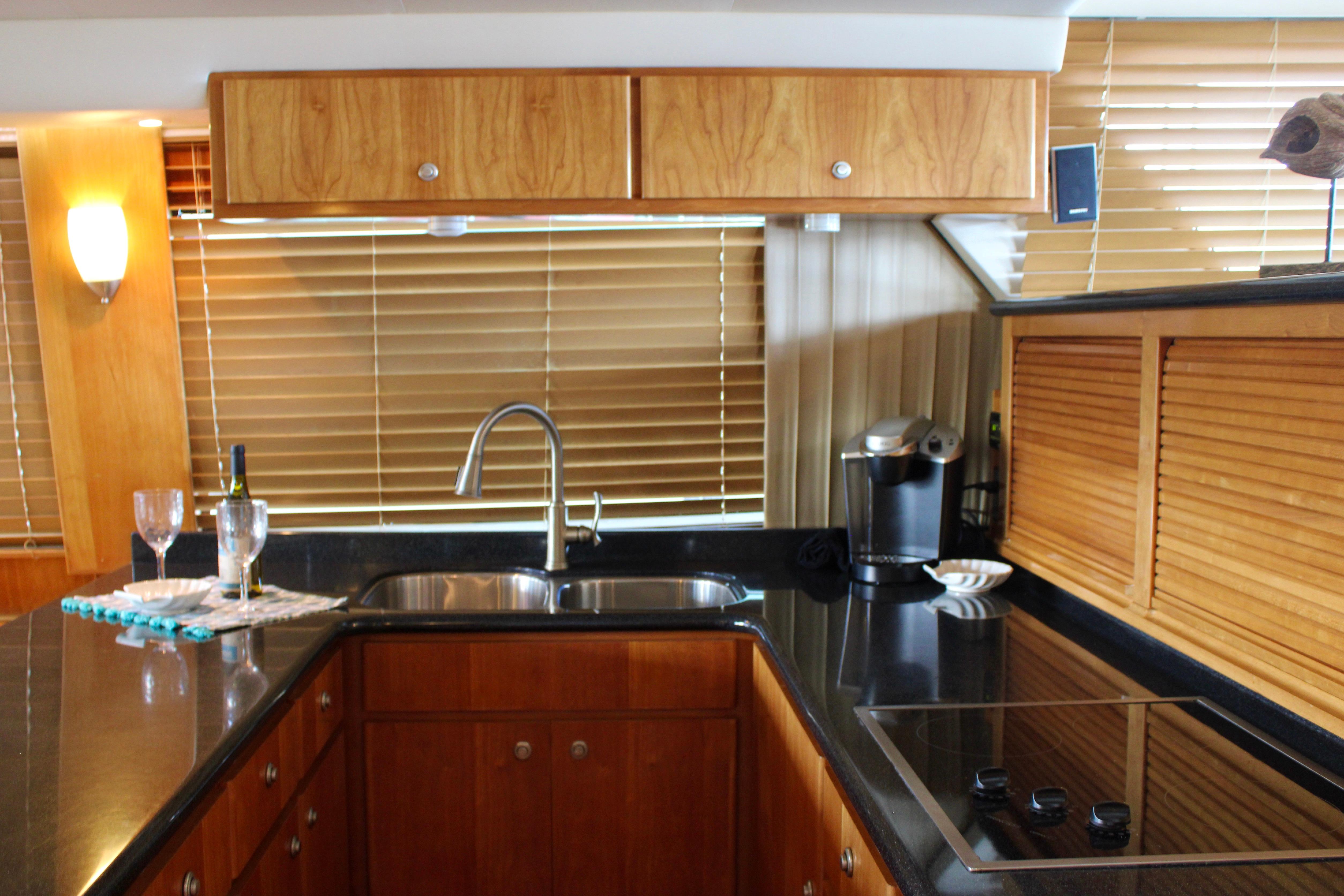 Luxurious kitchen interior of 2007 Navigator 5100 yacht with modern appliances and wooden cabinetry.