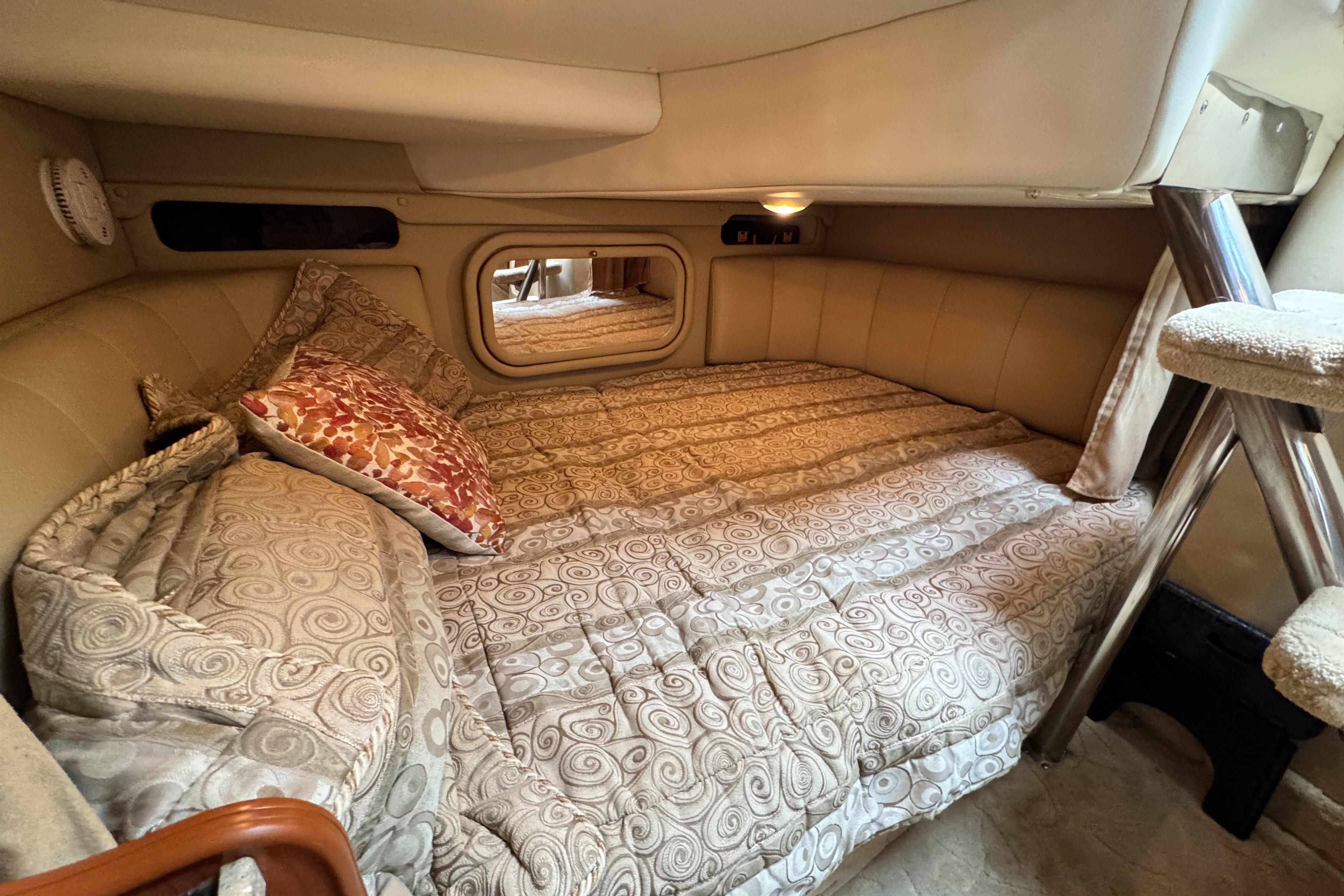 2005 Rinker Fiesta Vee 342 cabin interior with cozy bed and patterned bedding.