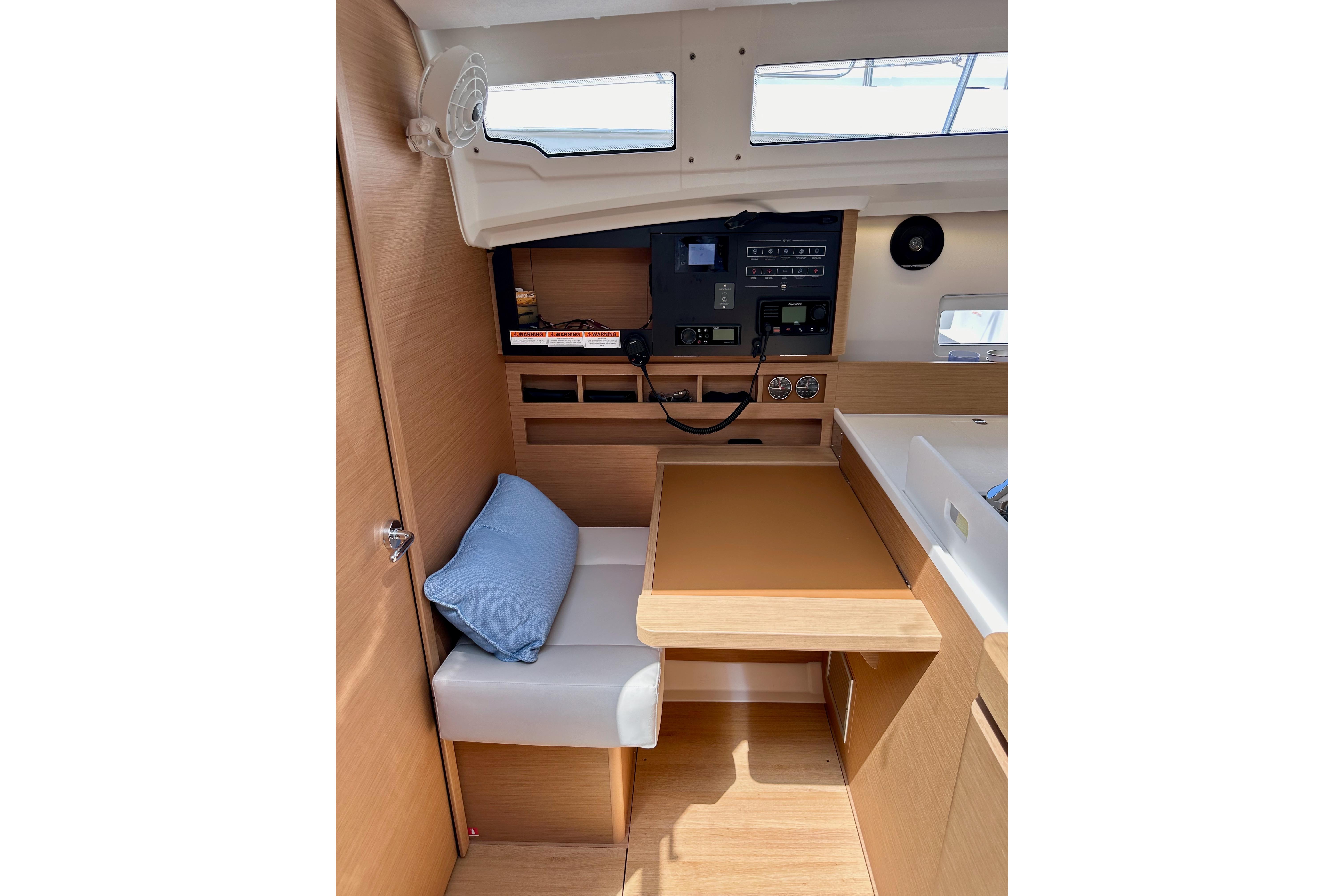 Interior of 2024 Jeanneau Sun Odyssey 410 sailboat with navigation station and seating area.