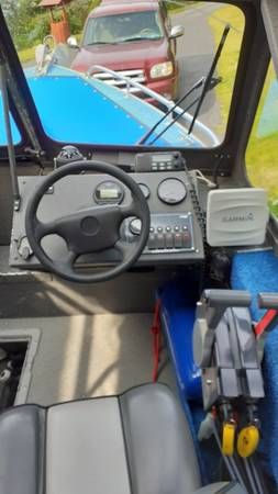 Interior view of a boat with steering and instruments.