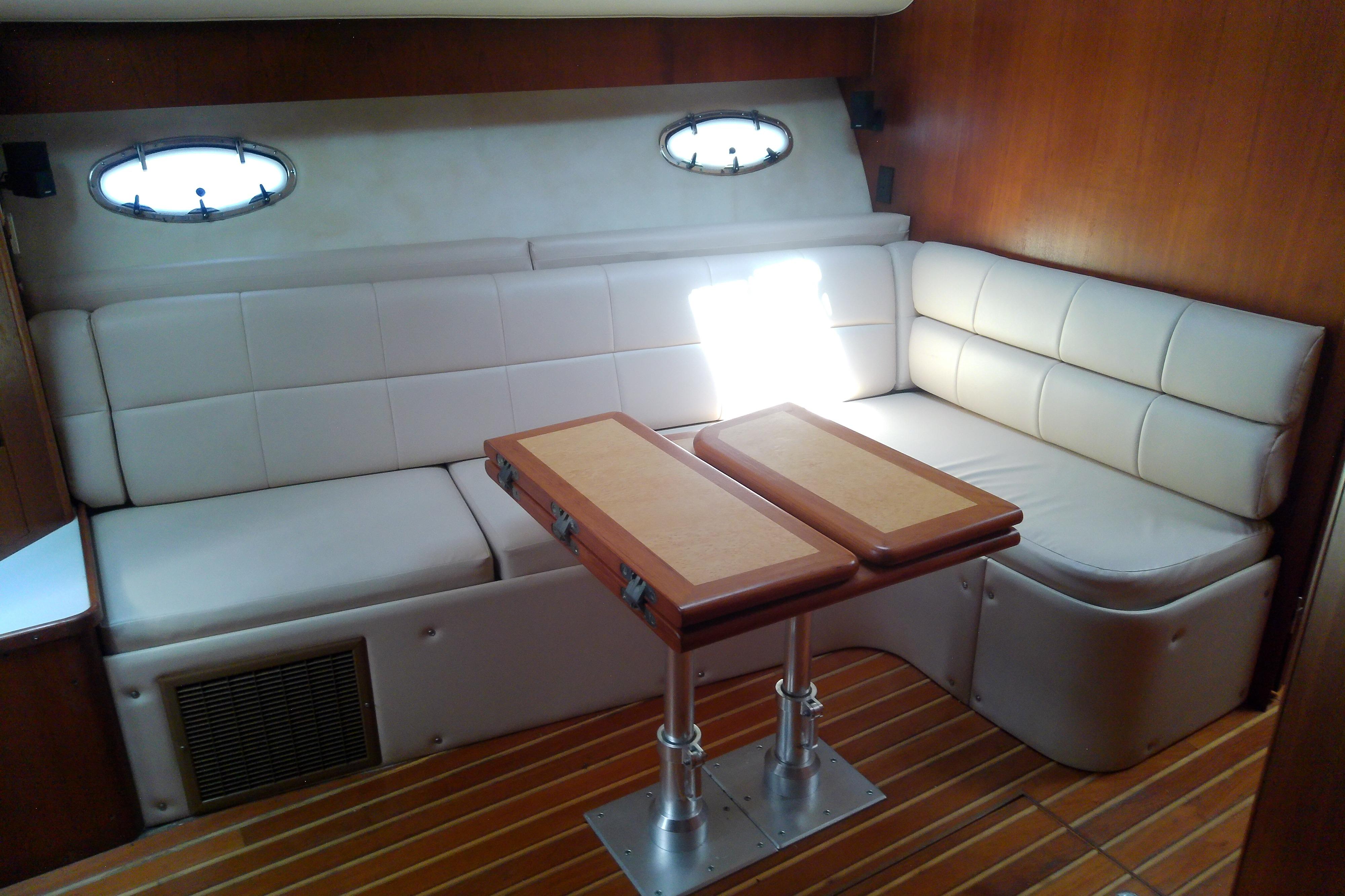 Interior of 2000 Tiara Yachts 4100 Open with white seating and wooden table.