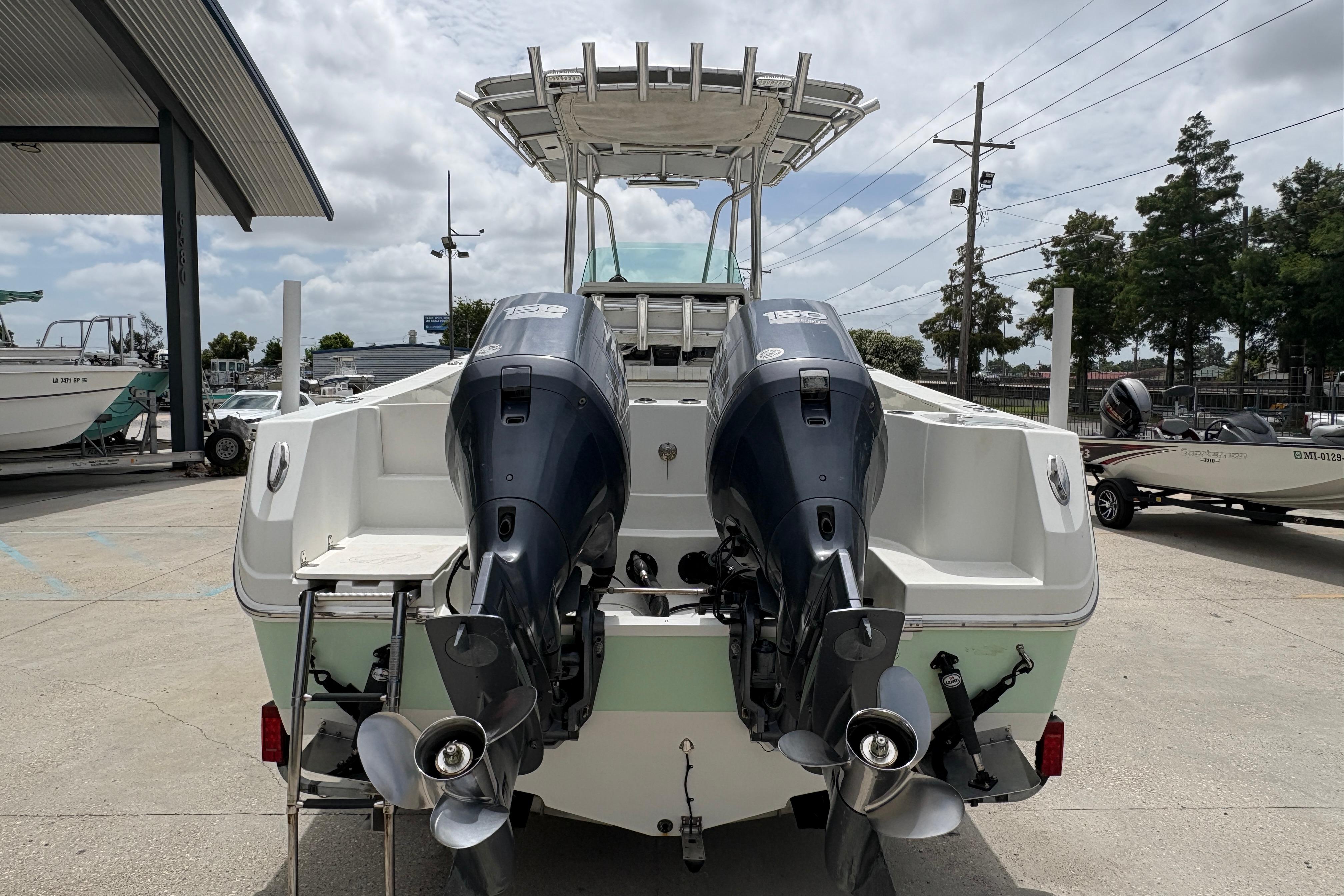 2006 Sail Faish 2360 boat with dual outboard motors in a marina setting.