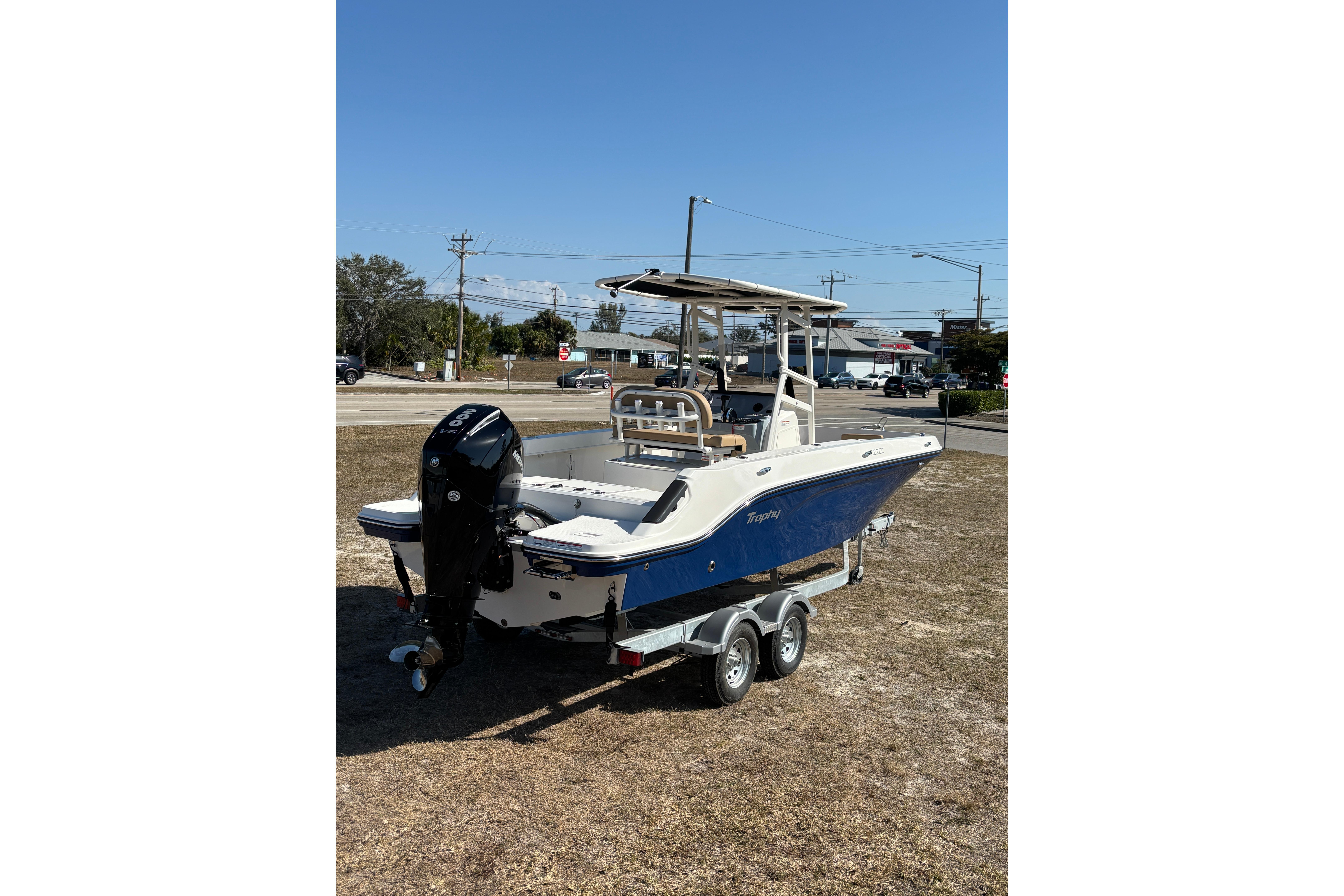 2026 Bayliner Trophy T22CC boat on trailer, parked outdoors under clear sky.