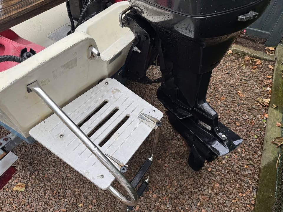 A 1976 Boston Whaler 17 Montauk with a swim ladder and an outboard motor.