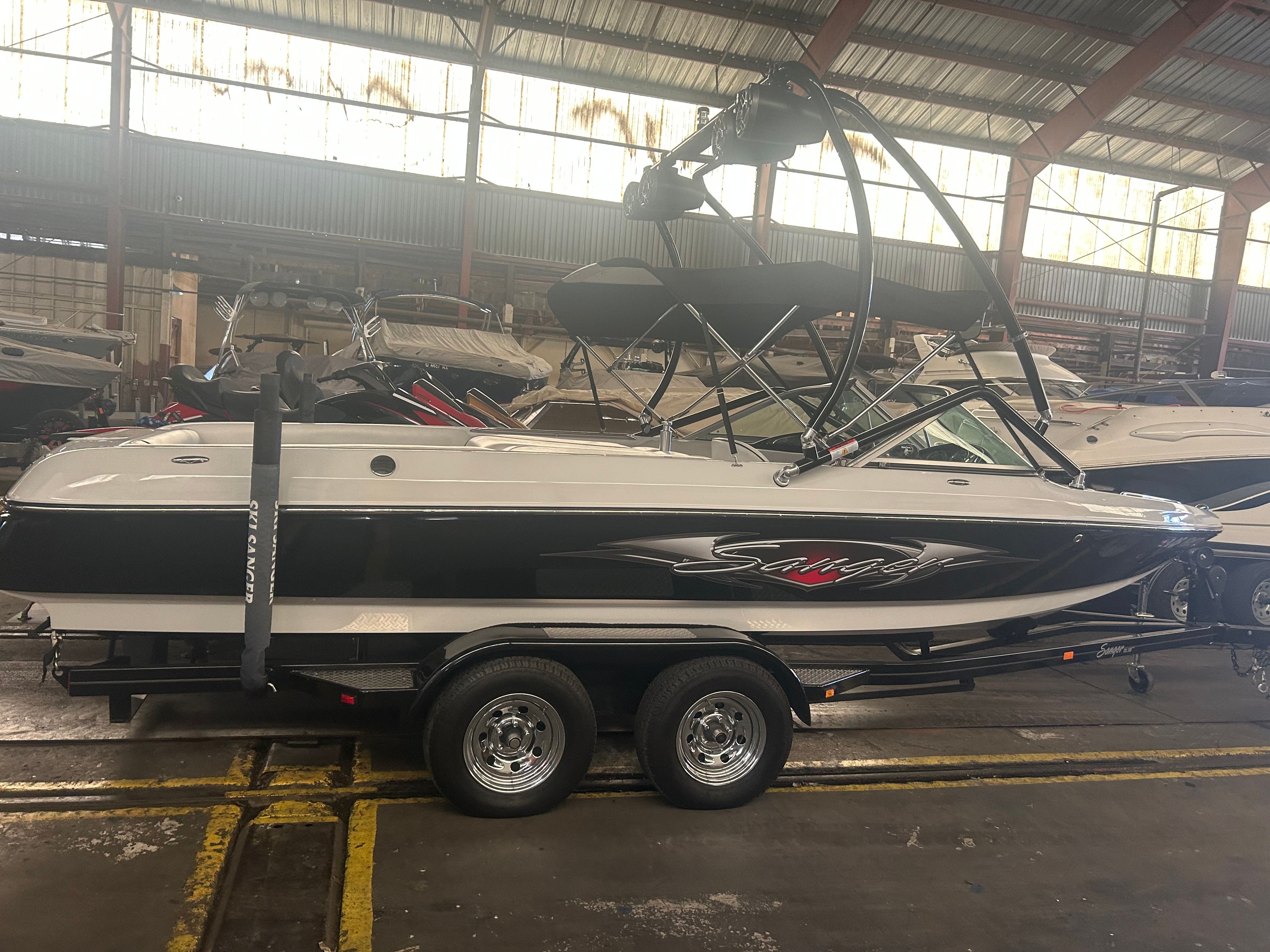 A 2007 Sanger boat on a trailer inside a warehouse.