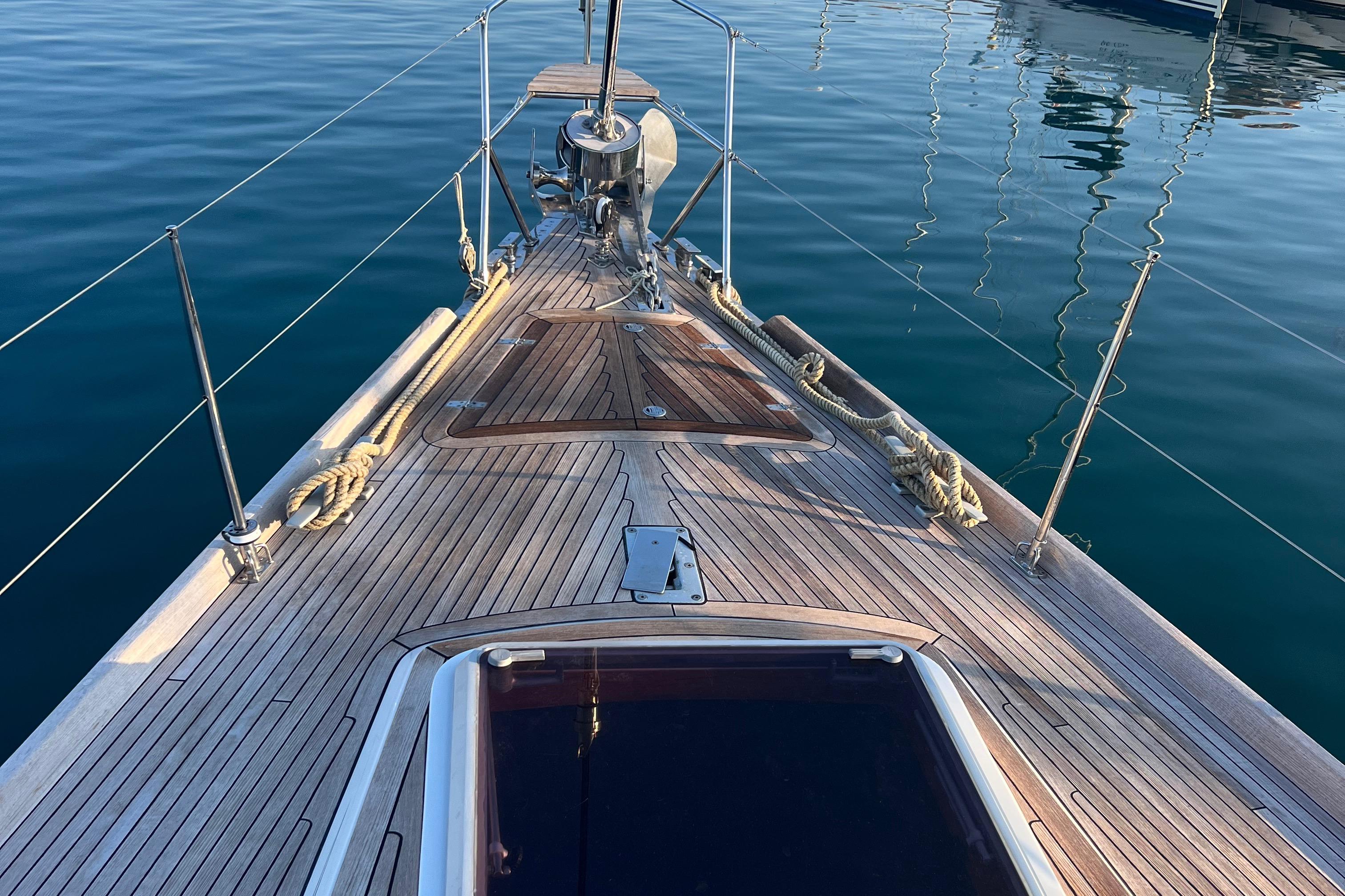 Deck view of 1986 Nautor Swan 61 yacht, showcasing elegant teak wood finish.
