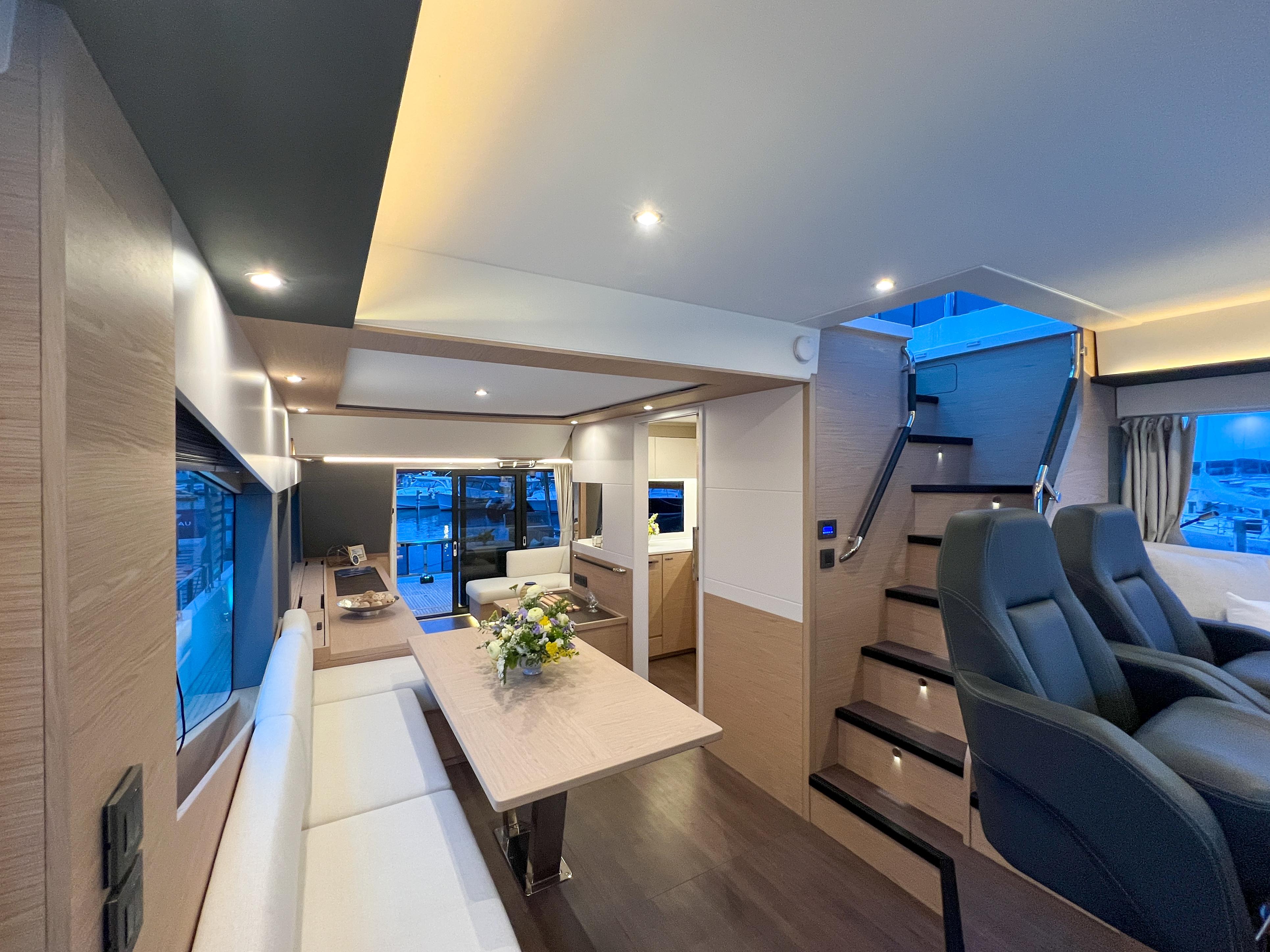 Luxurious interior of 2025 Beneteau Grand Trawler 62 with modern seating and dining area.