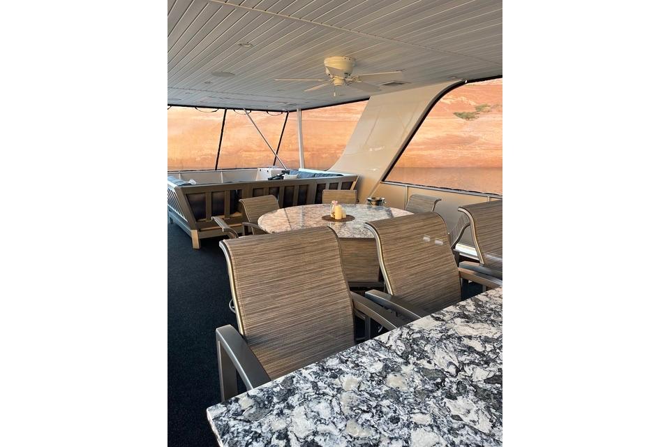 Luxurious dining area on Adonia's 2021 model, The Queen Elizabeth, featuring elegant seating and marble table.