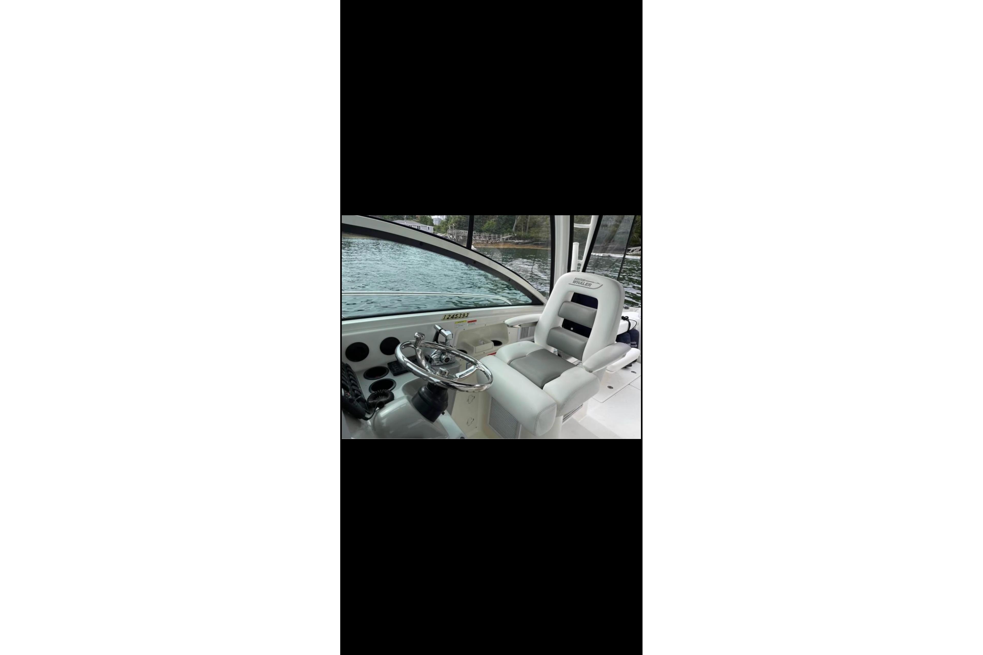 Interior view of 2013 Boston Whaler 315 Conquest boat cockpit with steering wheel and seat.