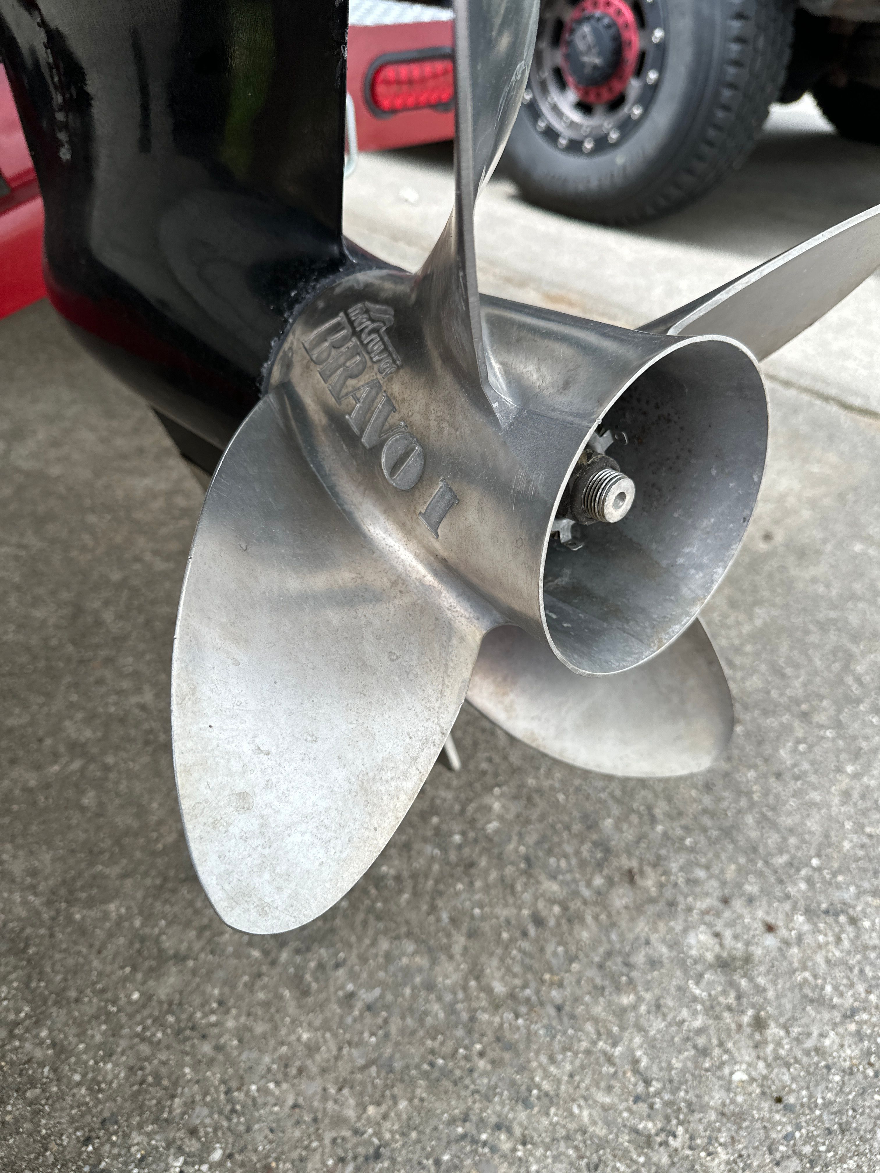 Close-up of a boat propeller on a concrete surface.