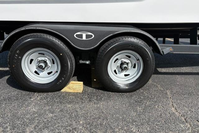 2024 Tahoe T21 trailer wheels on asphalt with wooden block support.