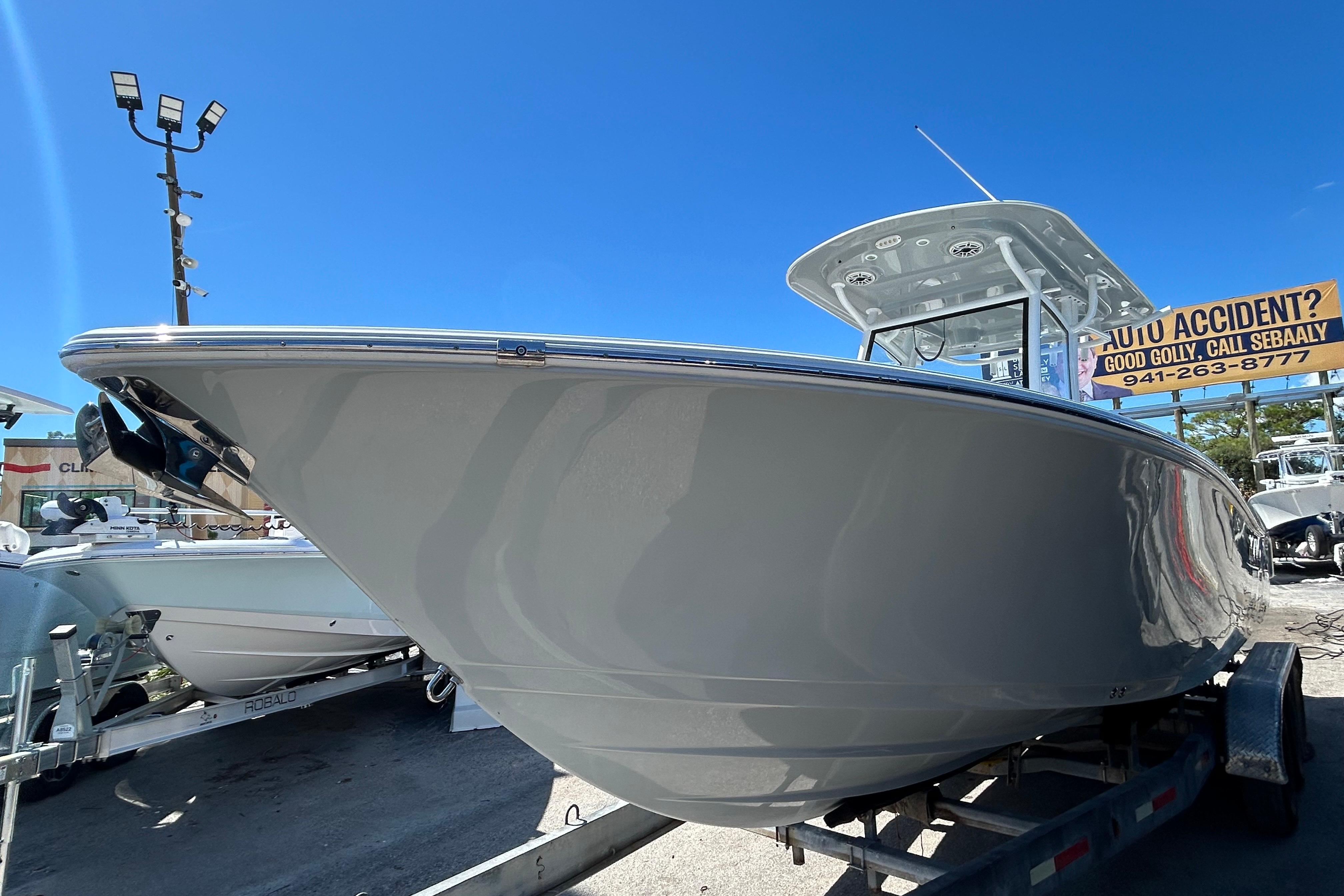 2019 Sportsman Open 282 Center Console boat on trailer under clear blue sky.