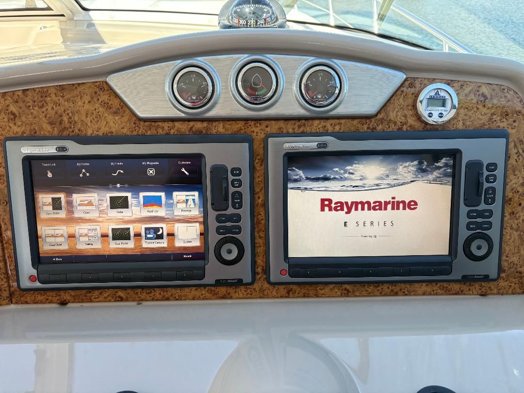 The dashboard of a 2011 Formula 45 with two Raymarine E Series screens and wood paneling.