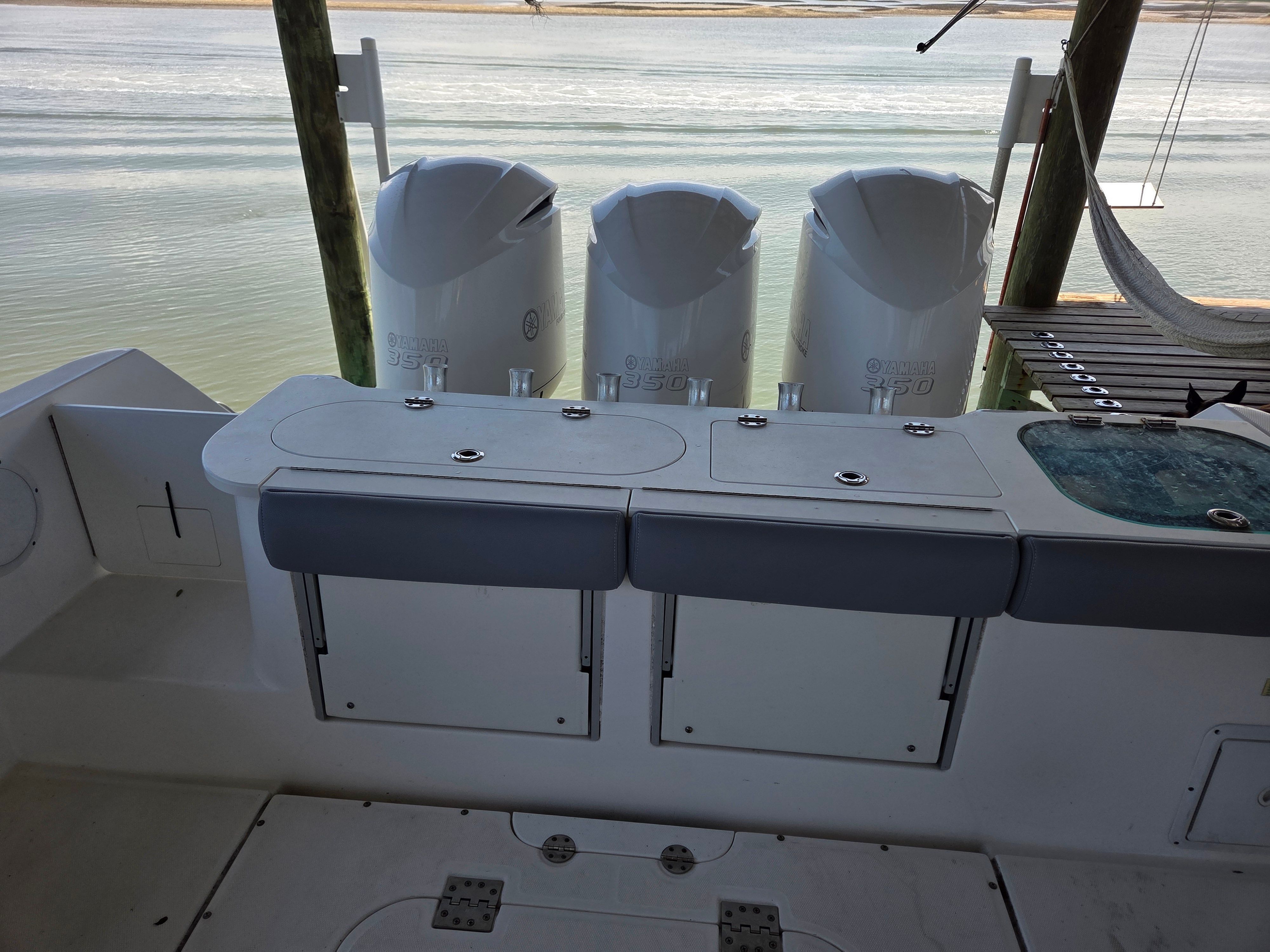 The image shows the stern of an Everglades 355 Center Console boat with three engines.