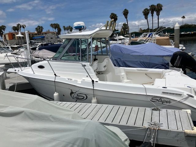 2011 Seaswirl Striper boat docked in marina with palm trees.