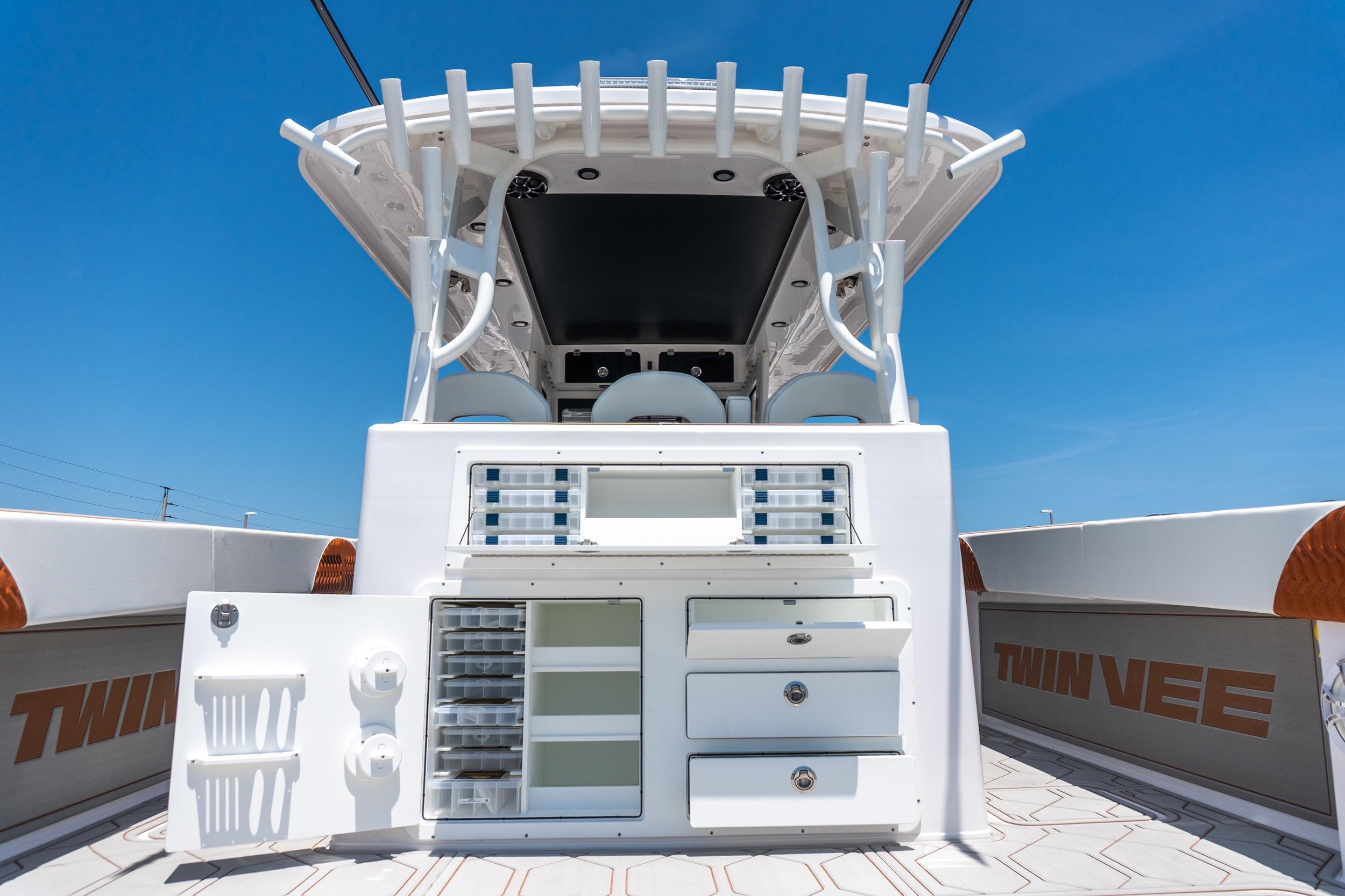 2026 Twin Vee 400 GFX2 CC boat interior with storage compartments under clear blue sky.