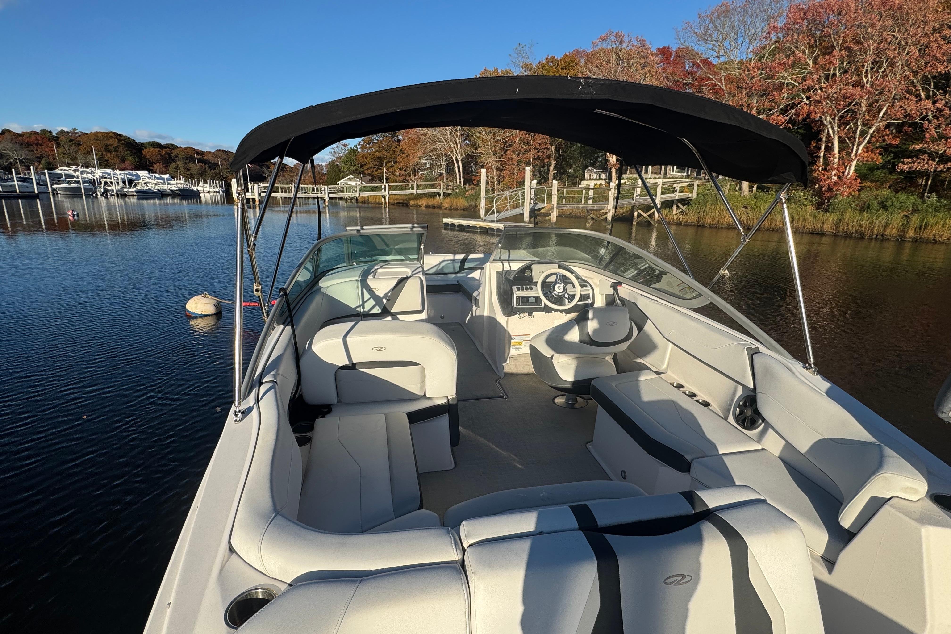 2017 Regal 23 OBX boat with canopy, docked on a serene lake.