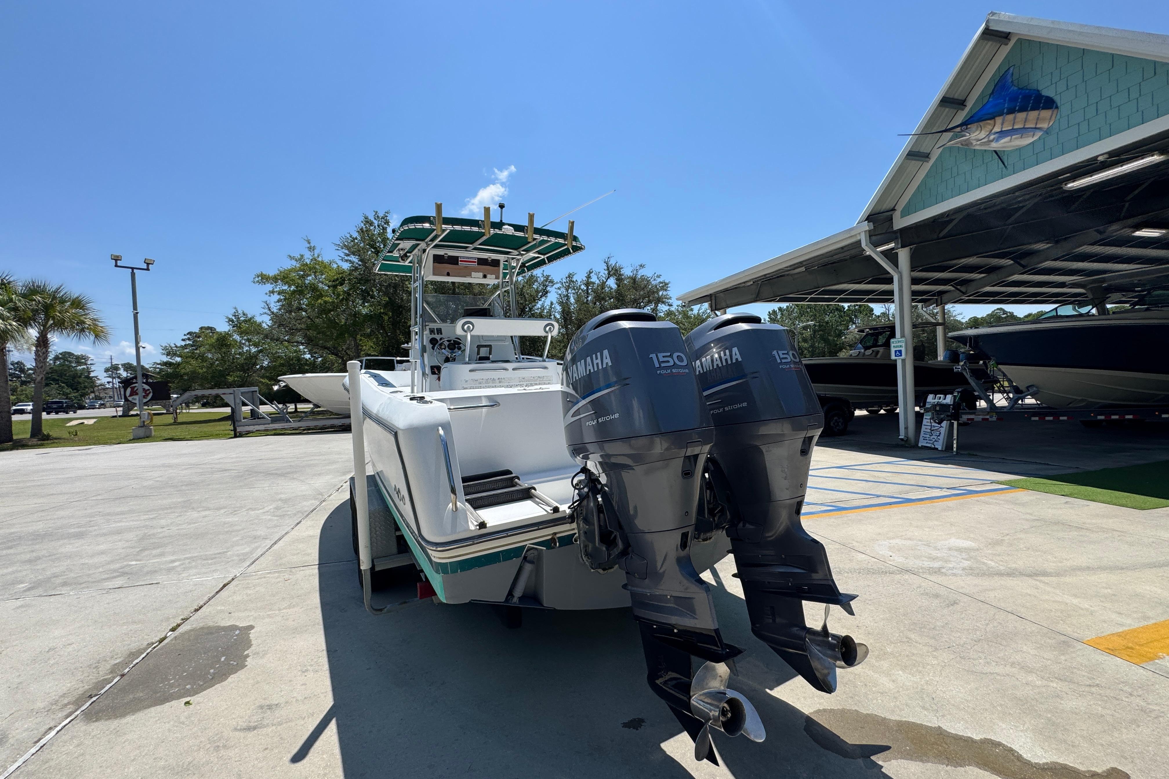 2000 Stamas 250 Tarpon boat with twin Yamaha 150 engines in a sunny marina.