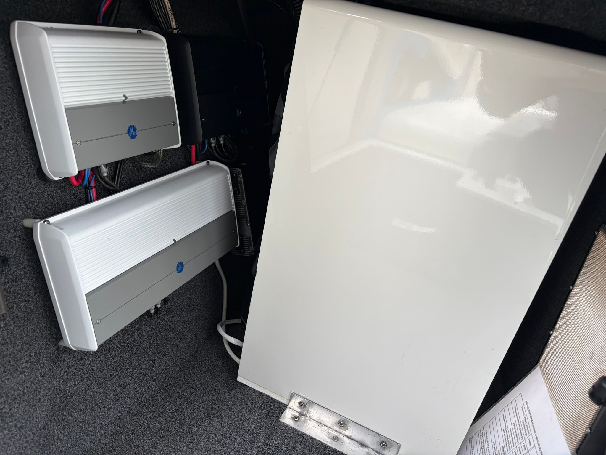 Interior view of a boat with two white speakers and a white panel.