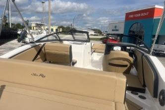 2017 Sea Ray SPX 210 Outboard boat with beige seating, docked under a partly cloudy sky.